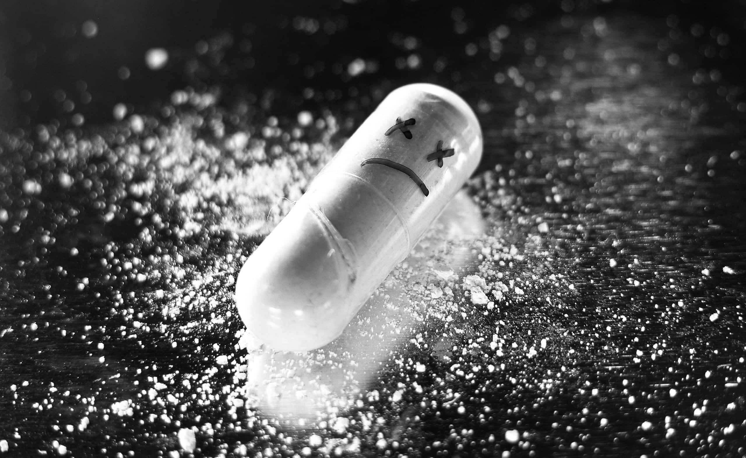 oblong pill, sad face, black and white photo, 2K Desktop Wallpaper