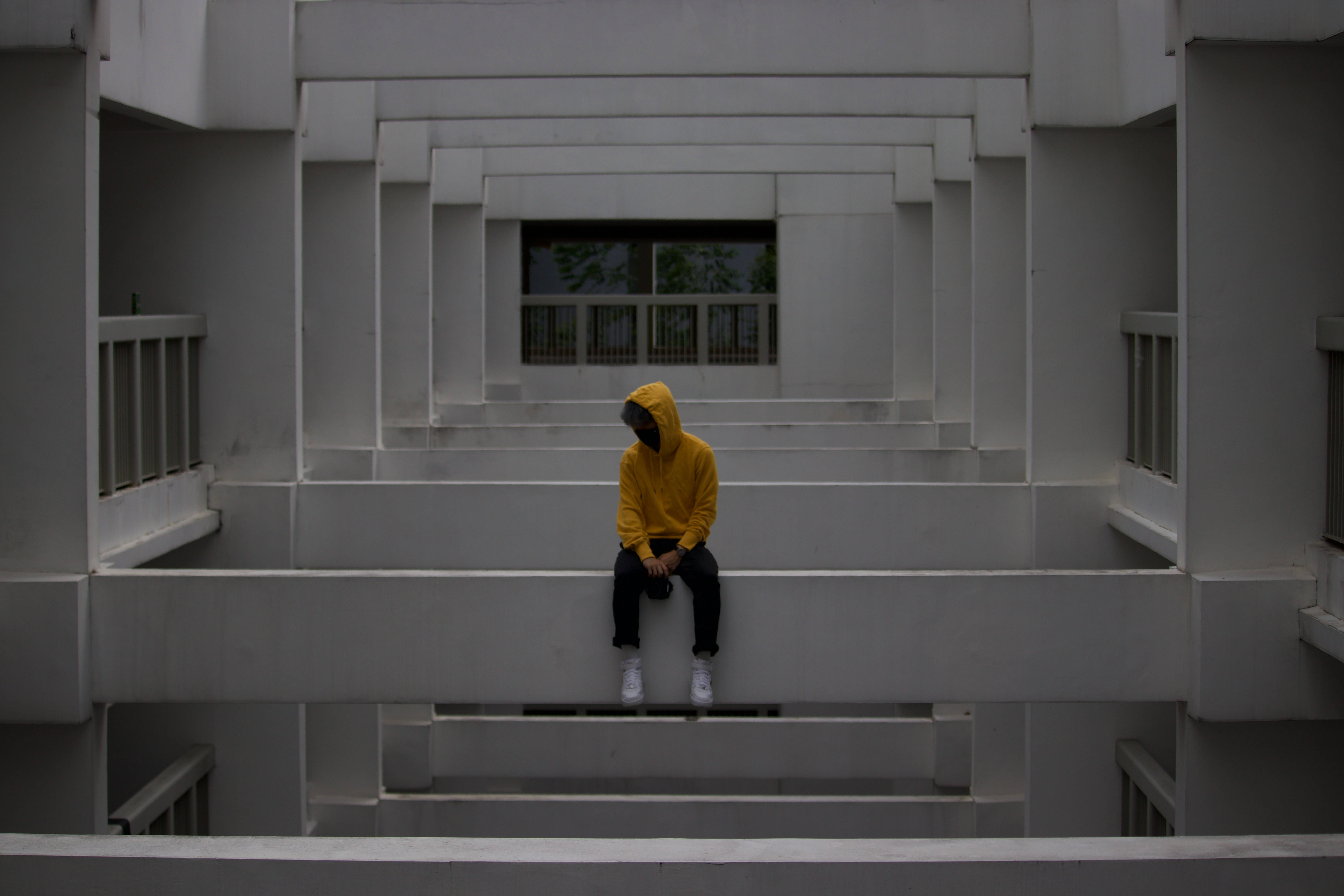 sad man yellow jacket, bright yellow hoodie, stark white concrete stairs, 5K Desktop Wallpaper