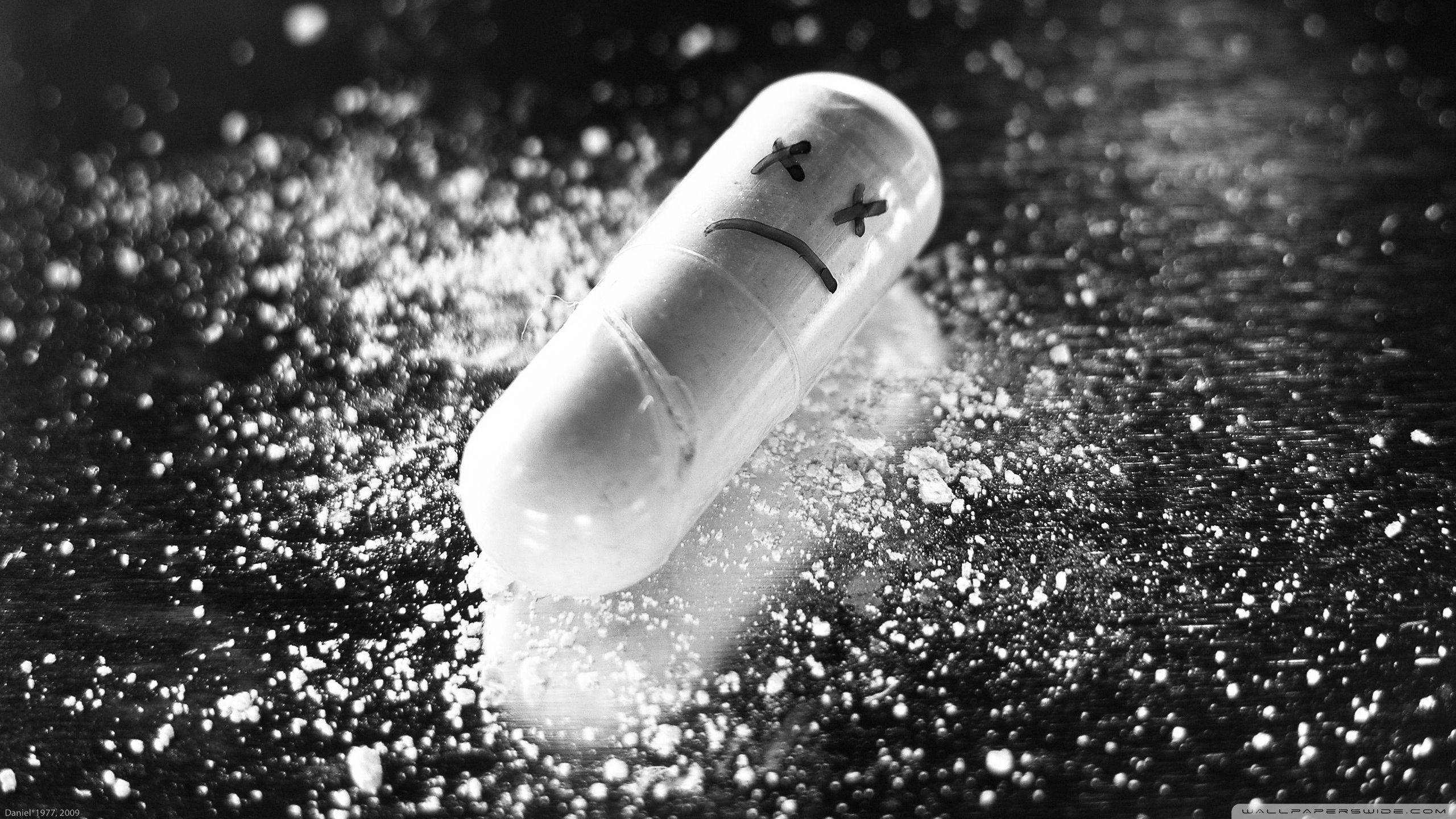 black and white, sad-faced pill, gritty surface, 2K Desktop Wallpaper