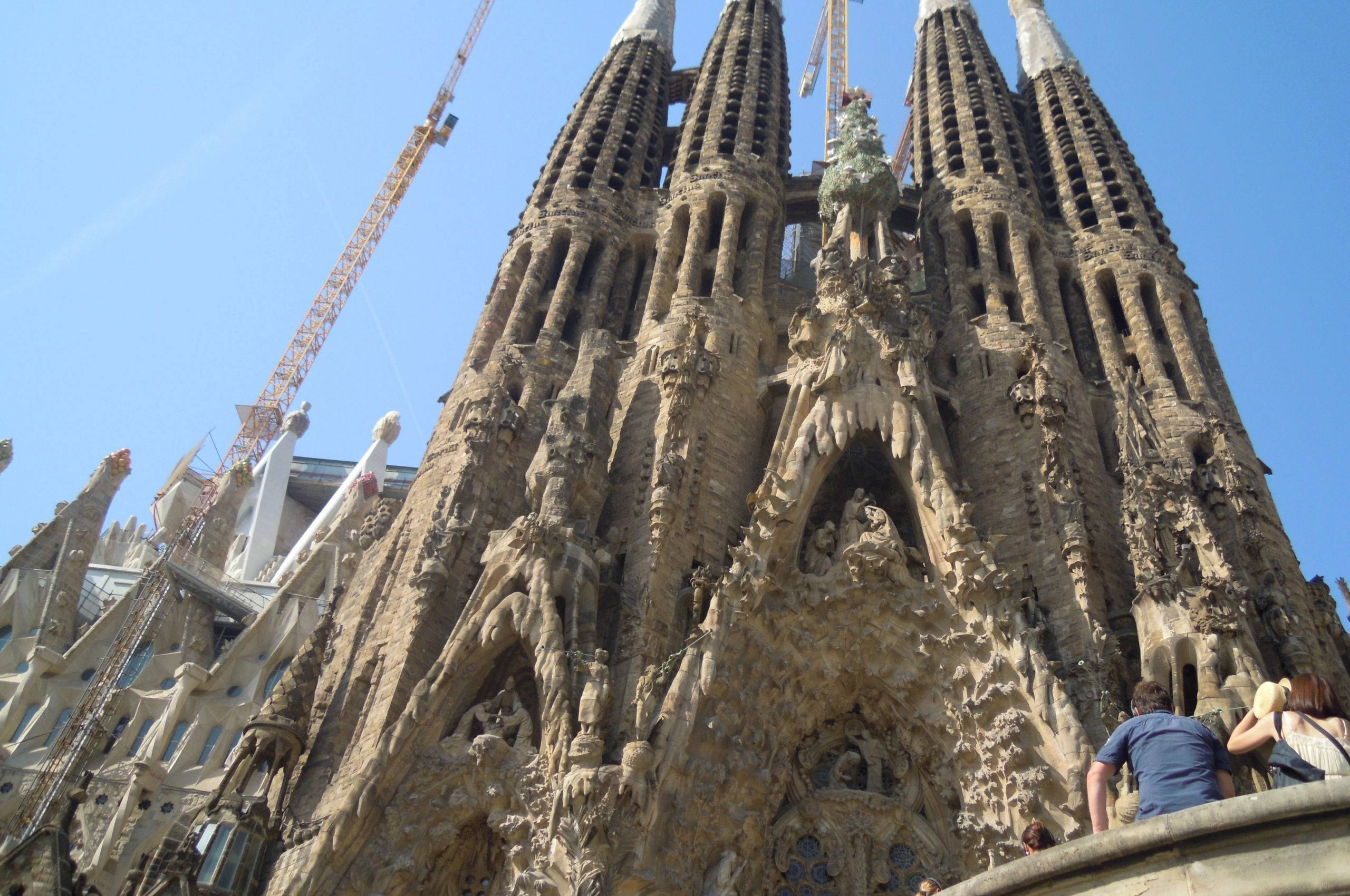 Sagrada Familia, ornate stone facade, clear blue sky, 2K Desktop Wallpaper