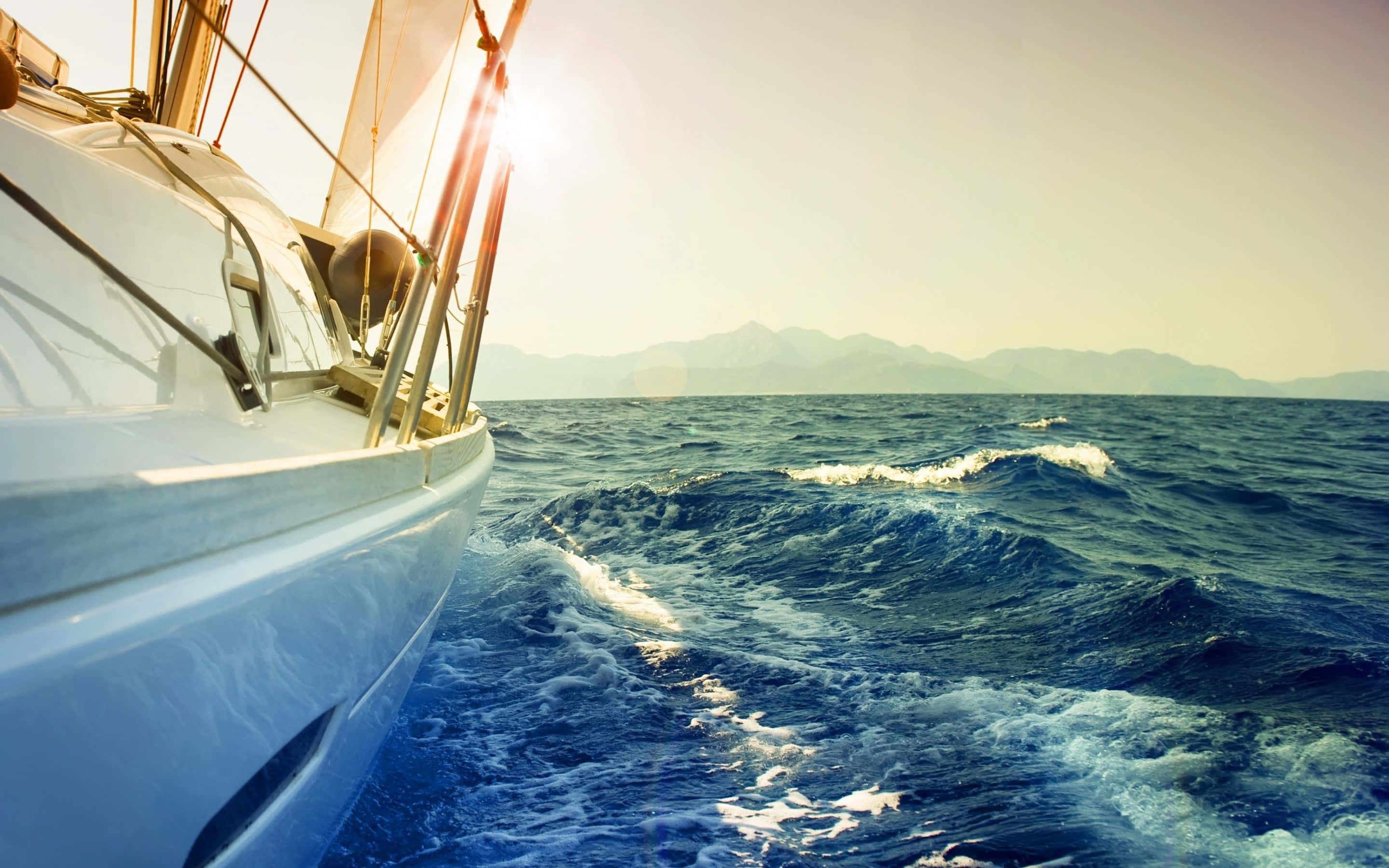 sailboat, sun flaring, deep blue ocean waves, 2K Desktop Wallpaper