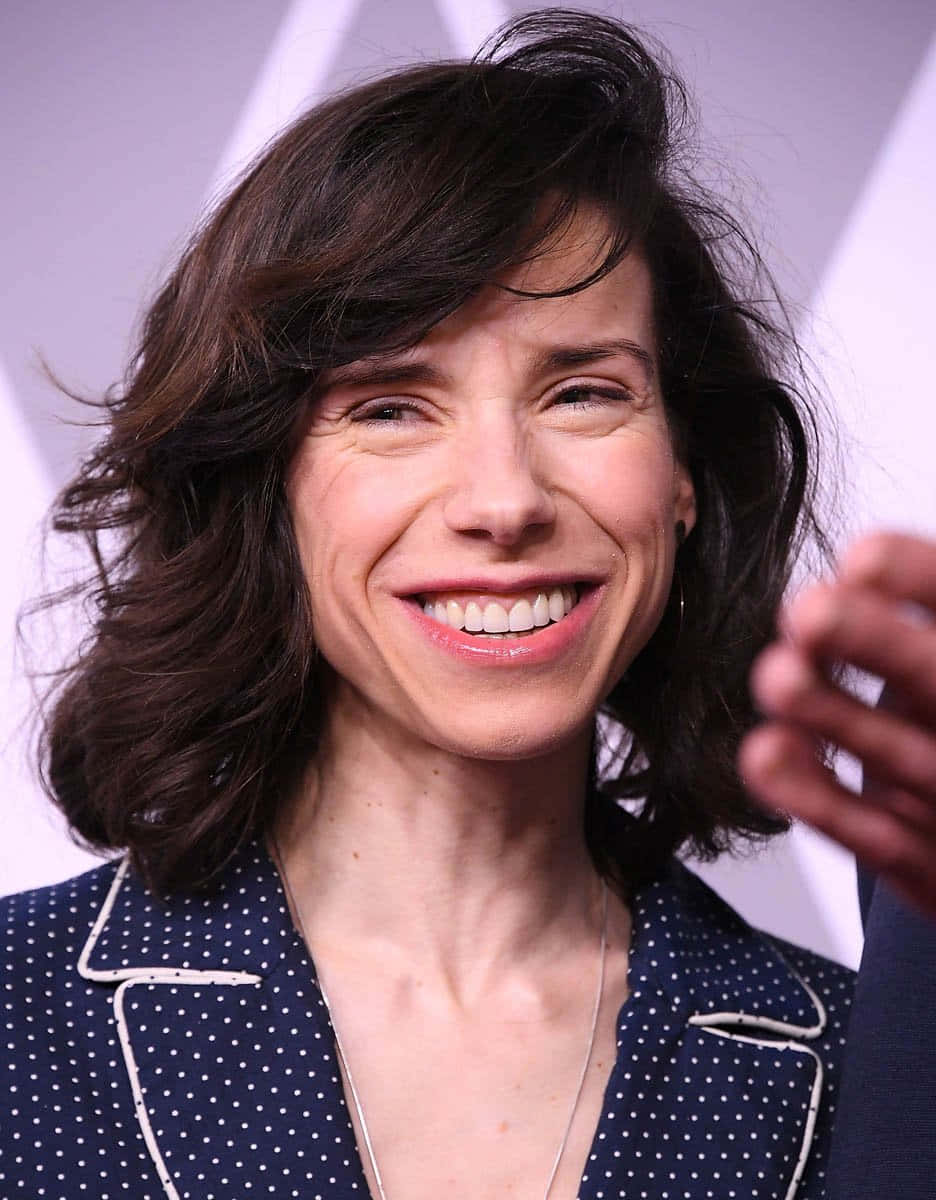 Sally Hawkins, navy polka-dot blazer, soft purple geometric backdrop, SD Phone Wallpaper