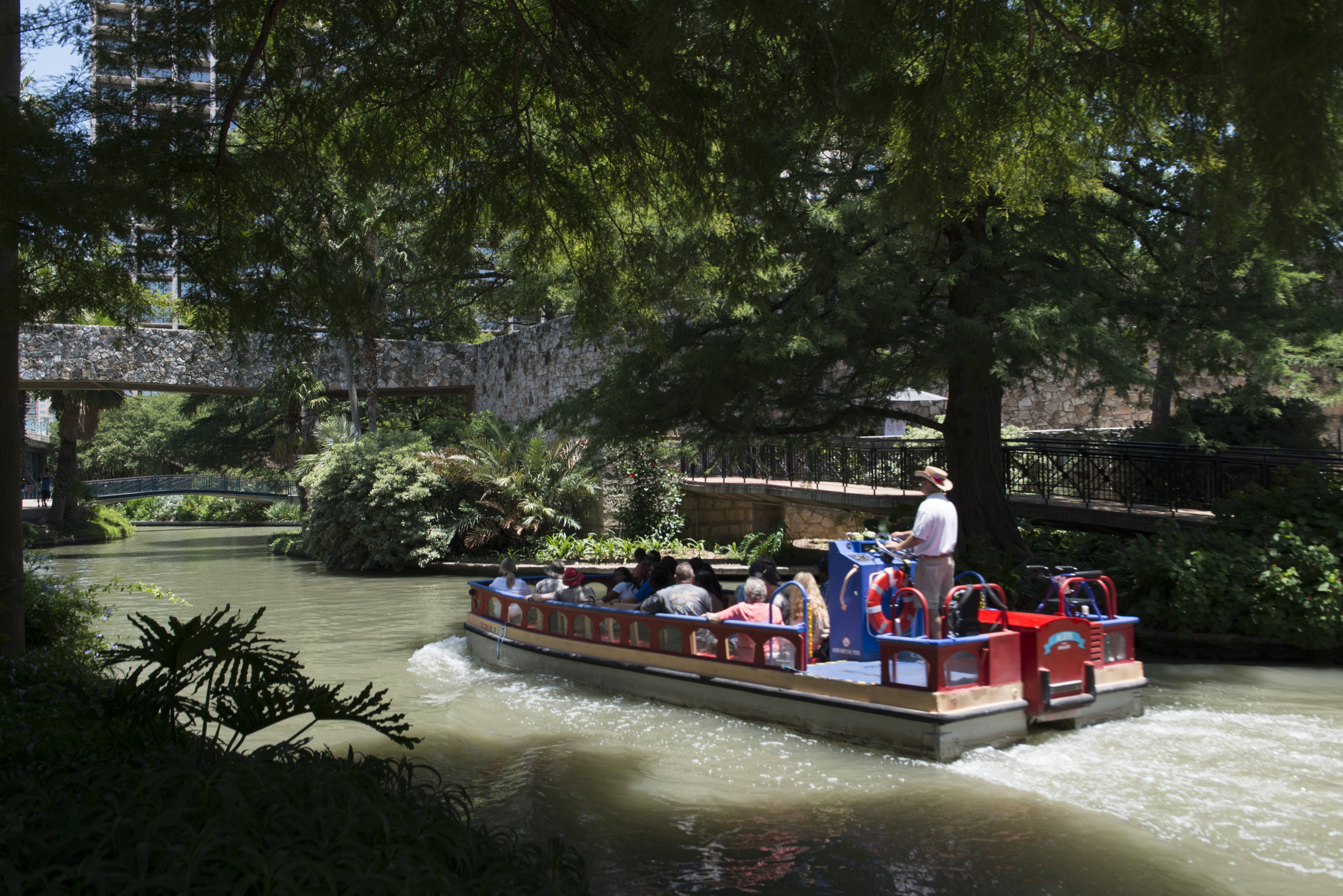 San Antonio River Walk, red and blue tour boat, tree-lined urban canal, 5K Desktop Wallpaper