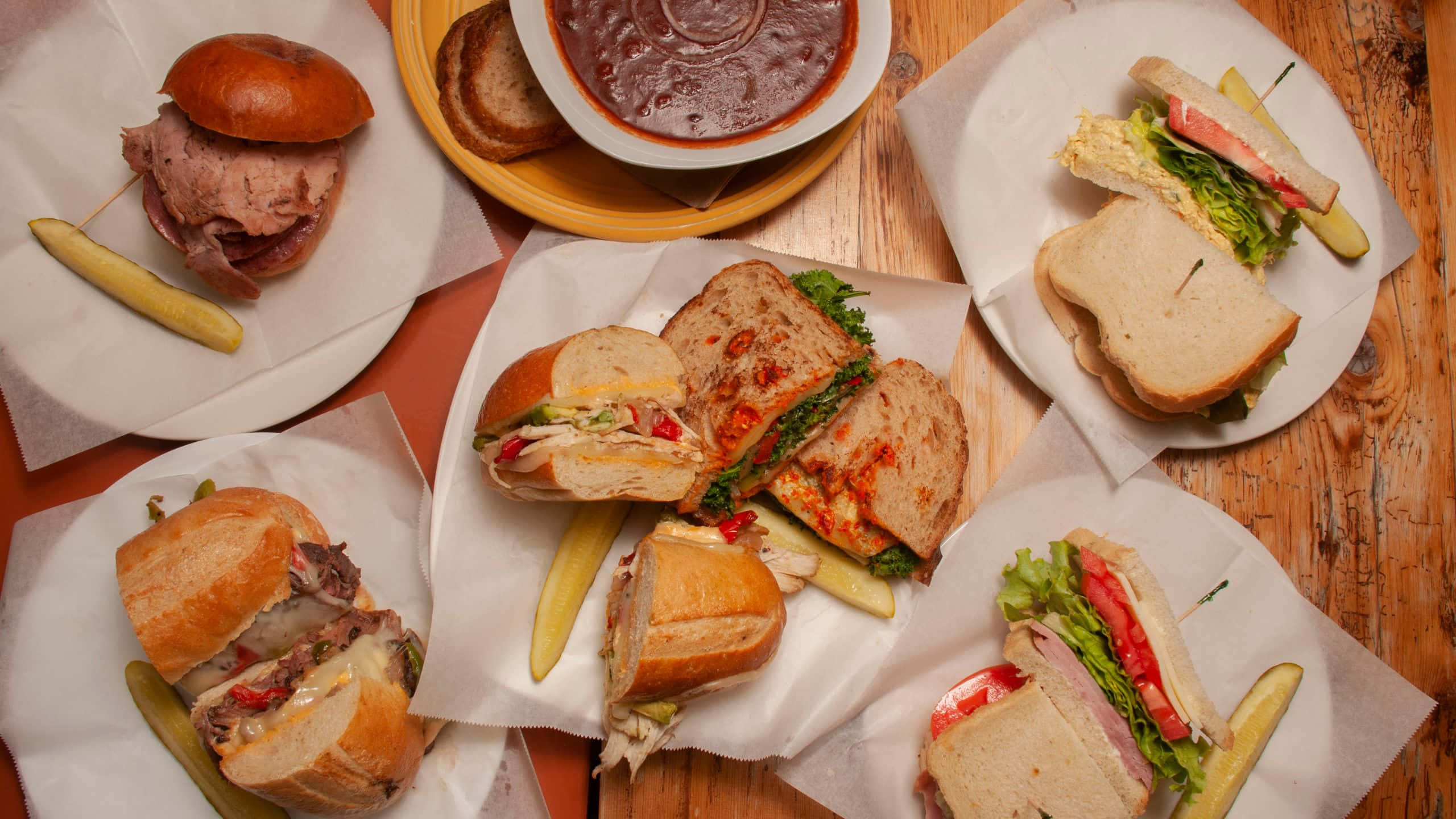 rustic wooden table, freshly made sandwiches, bowl of rich sauce, 2K Desktop Wallpaper
