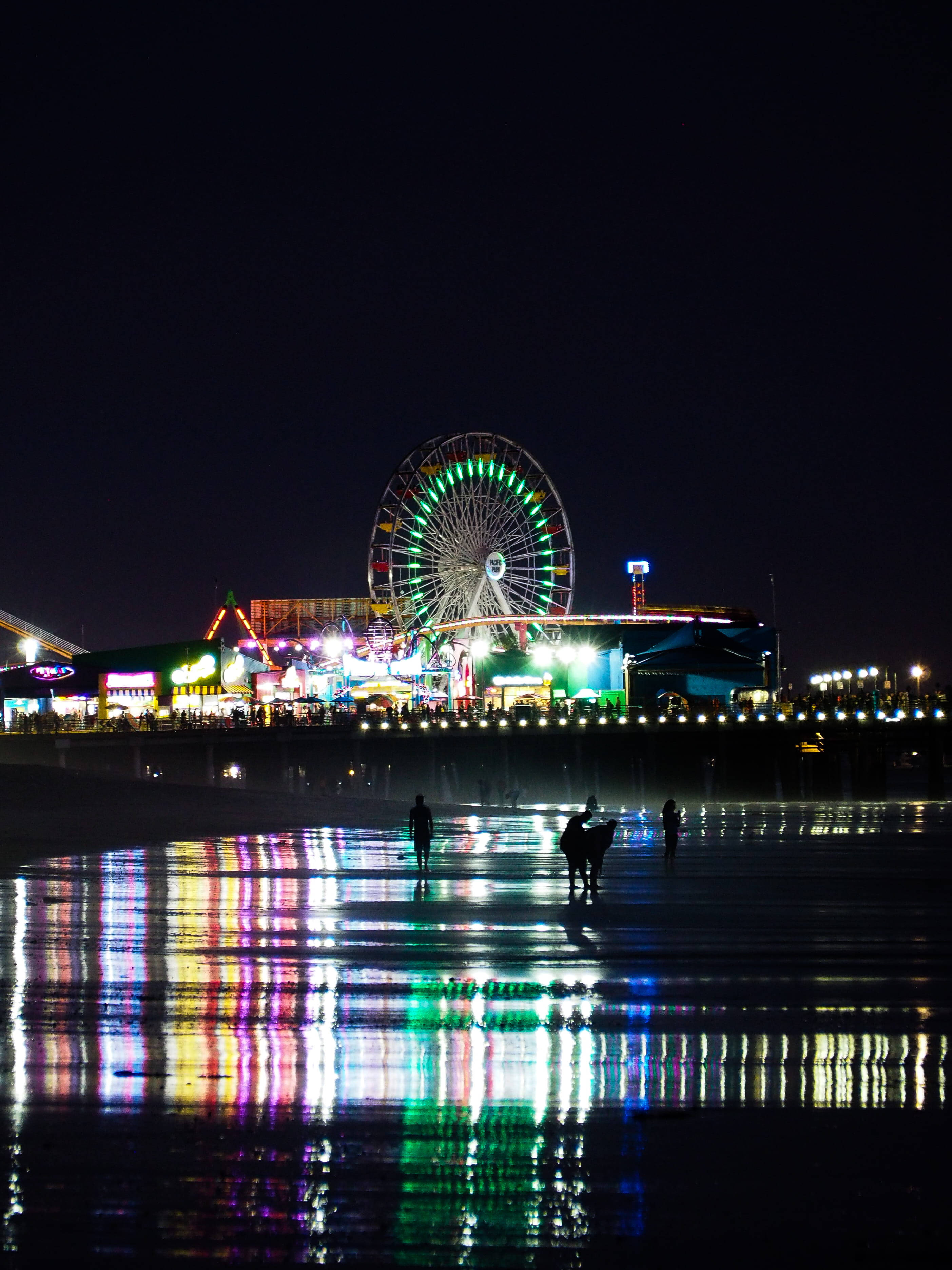 Santa Monica Beach, vibrant carnival lights, wet sand, 2K Phone Wallpaper