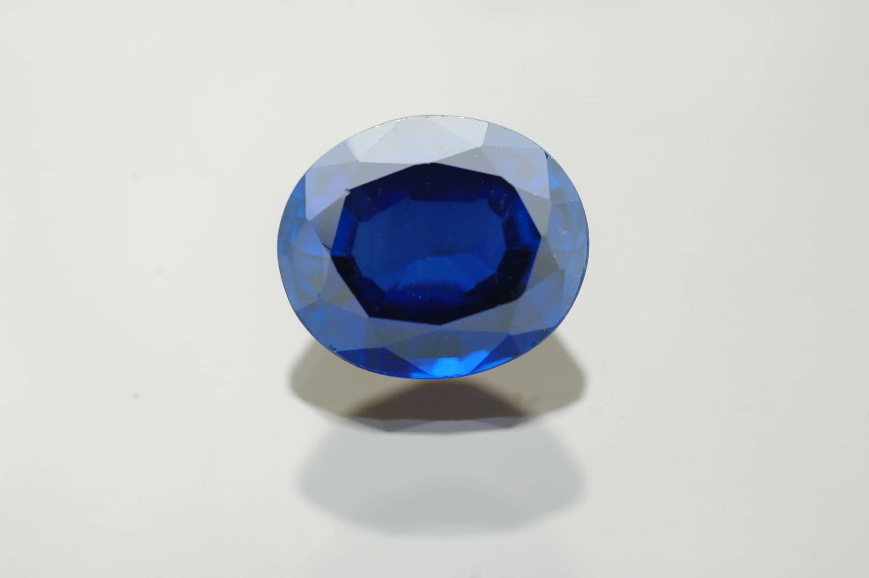 sapphire blue, oval-cut sapphire gemstone, precision facets, 2K Desktop Wallpaper