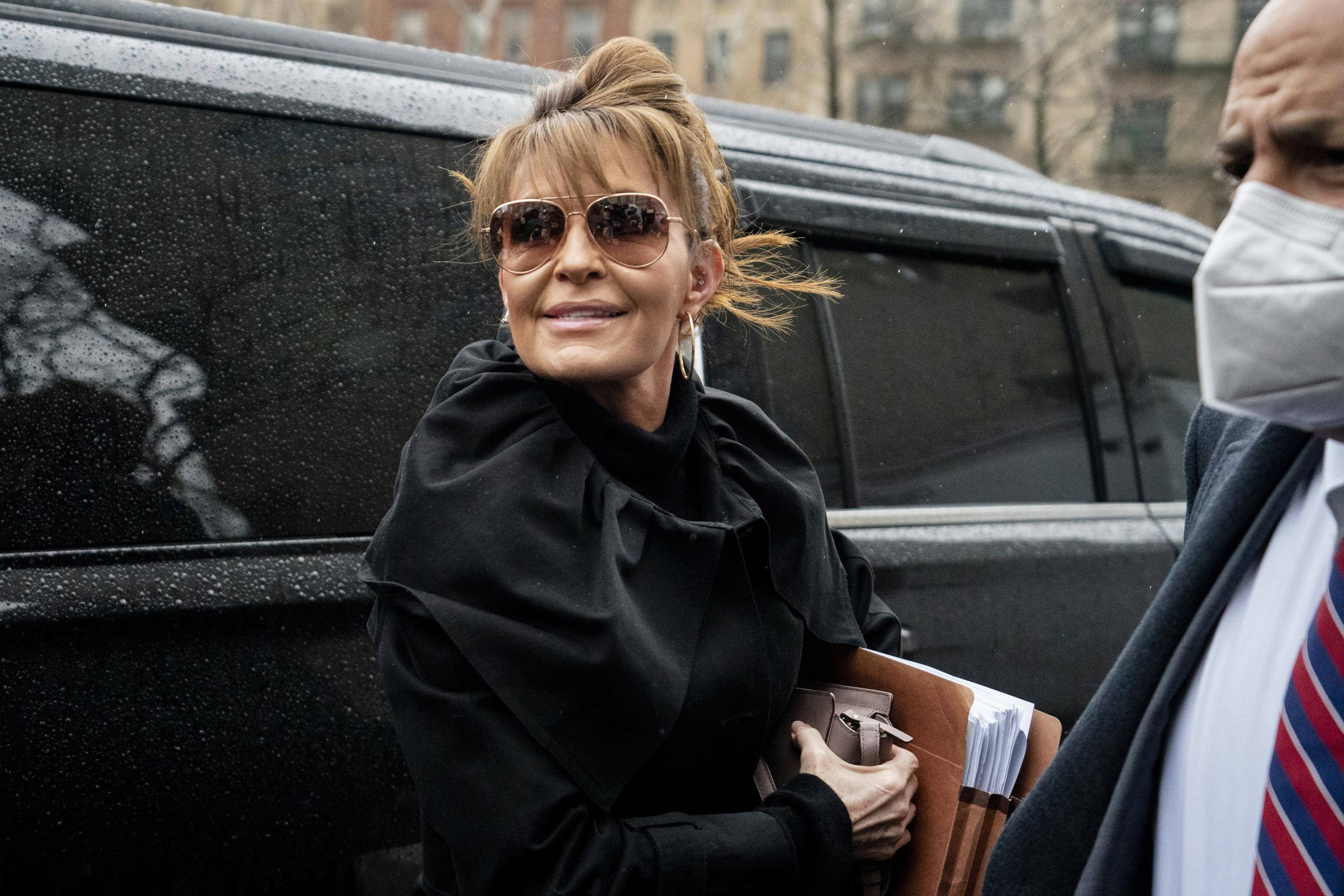 Sarah Palin, black SUV, rainy urban street, 2K Desktop Wallpaper