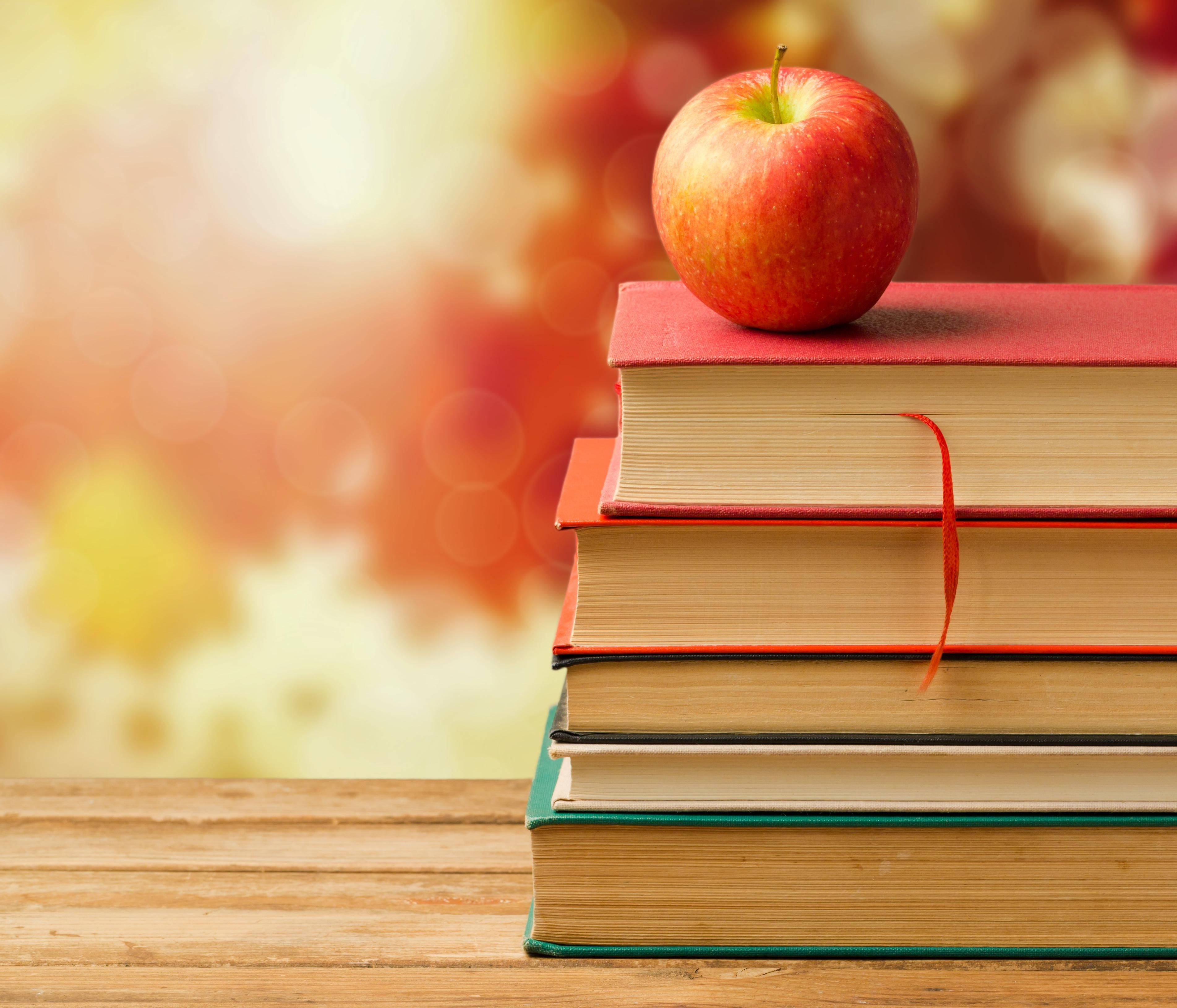 shiny red apple, colorful books, wooden surface, 2K Desktop Wallpaper