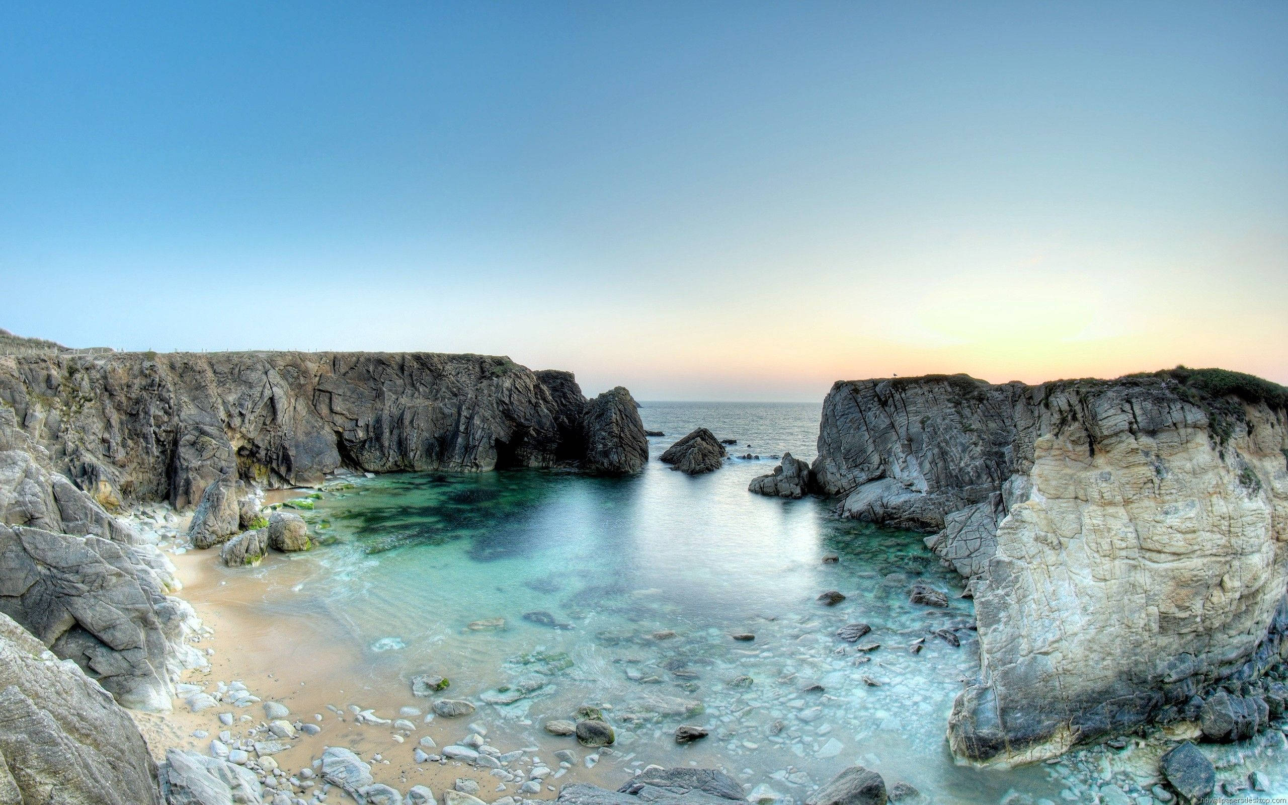 rocky seaside landscape, secluded cove, turquoise water, 2K Desktop Wallpaper