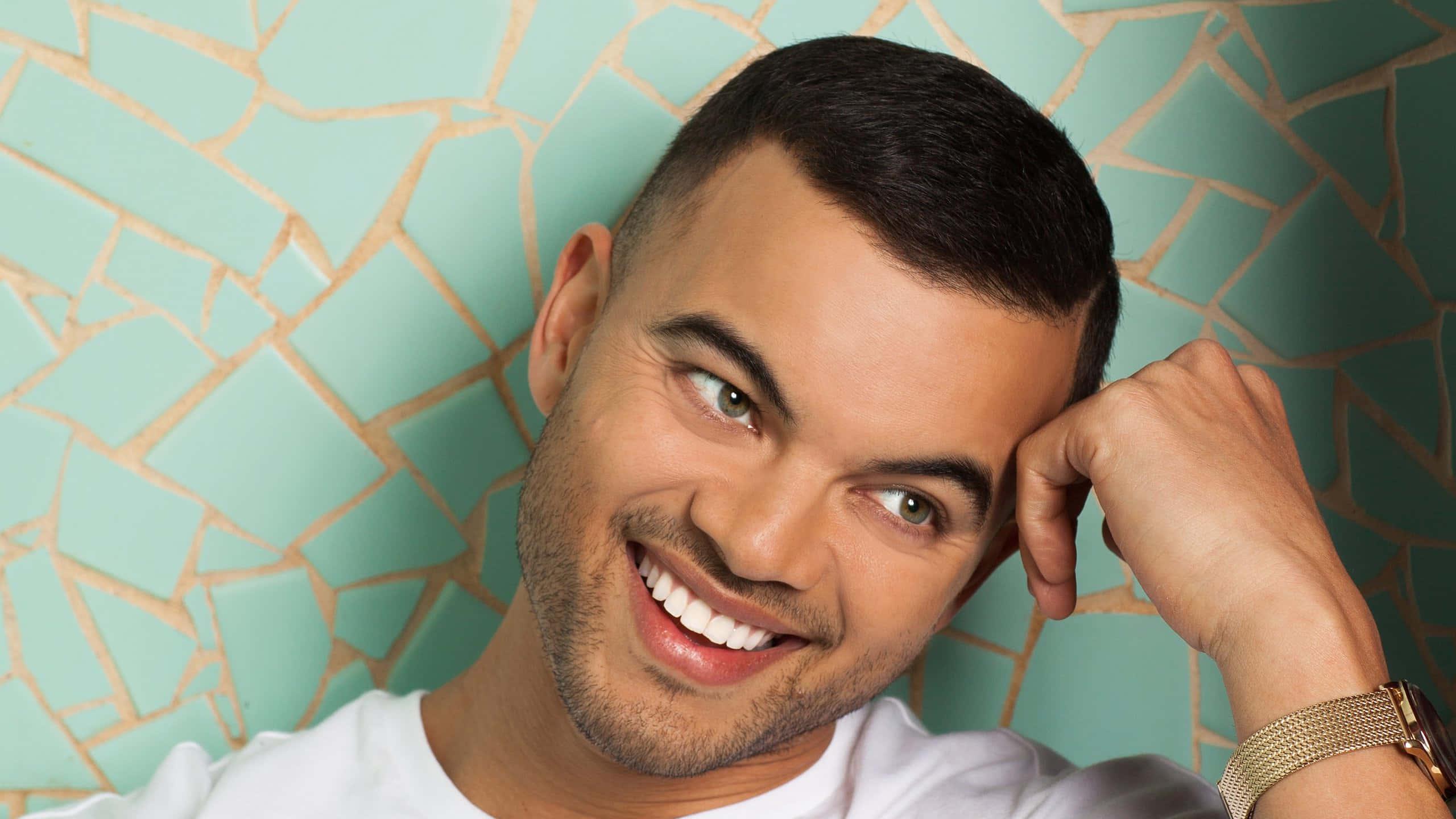 Guy Sebastian, teal mosaic tile wall, short dark hair, 2K Desktop Wallpaper