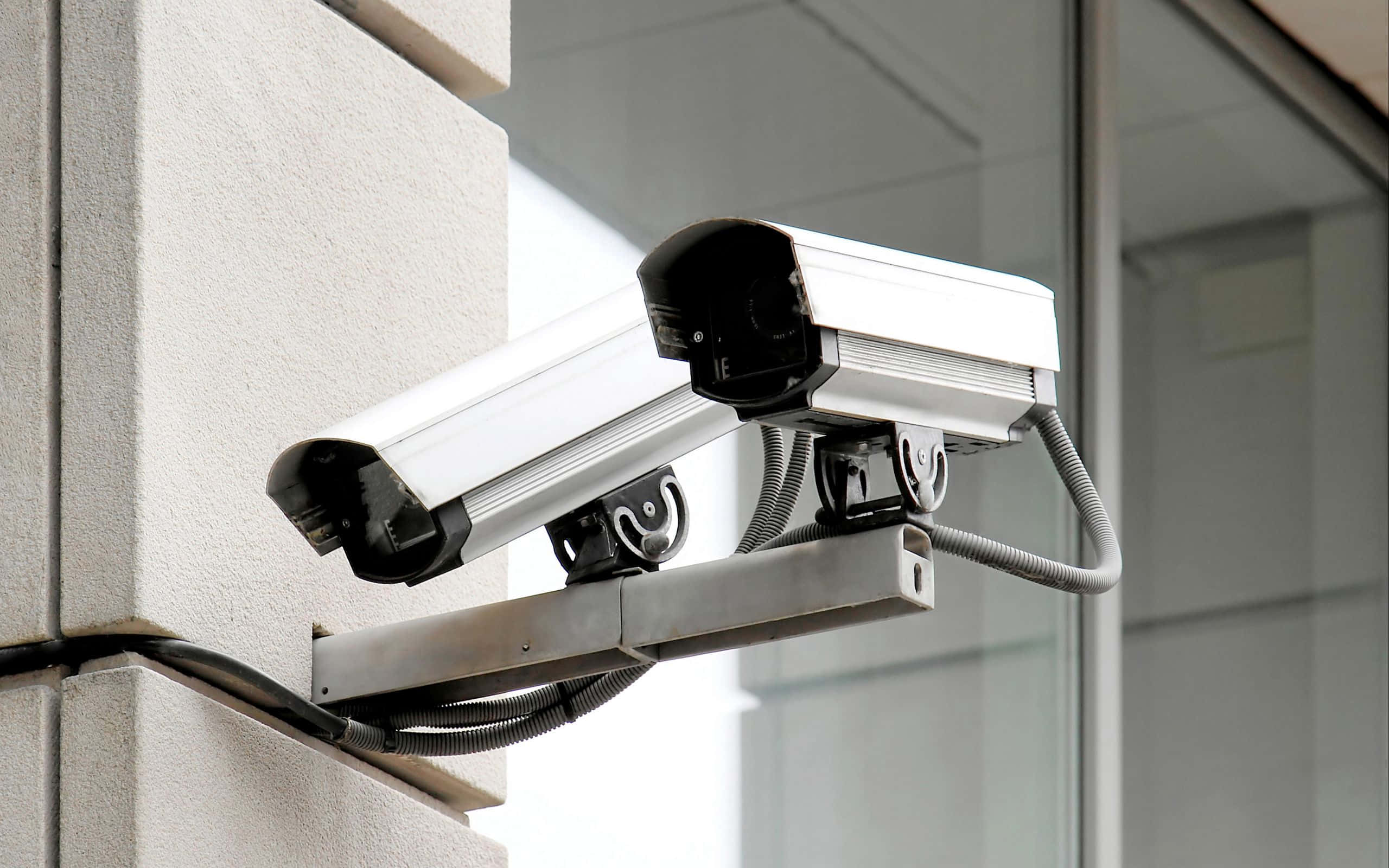 twin outdoor varifocal motorized zoom bullet security cameras, white, concrete wall, 2K Desktop Wallpaper