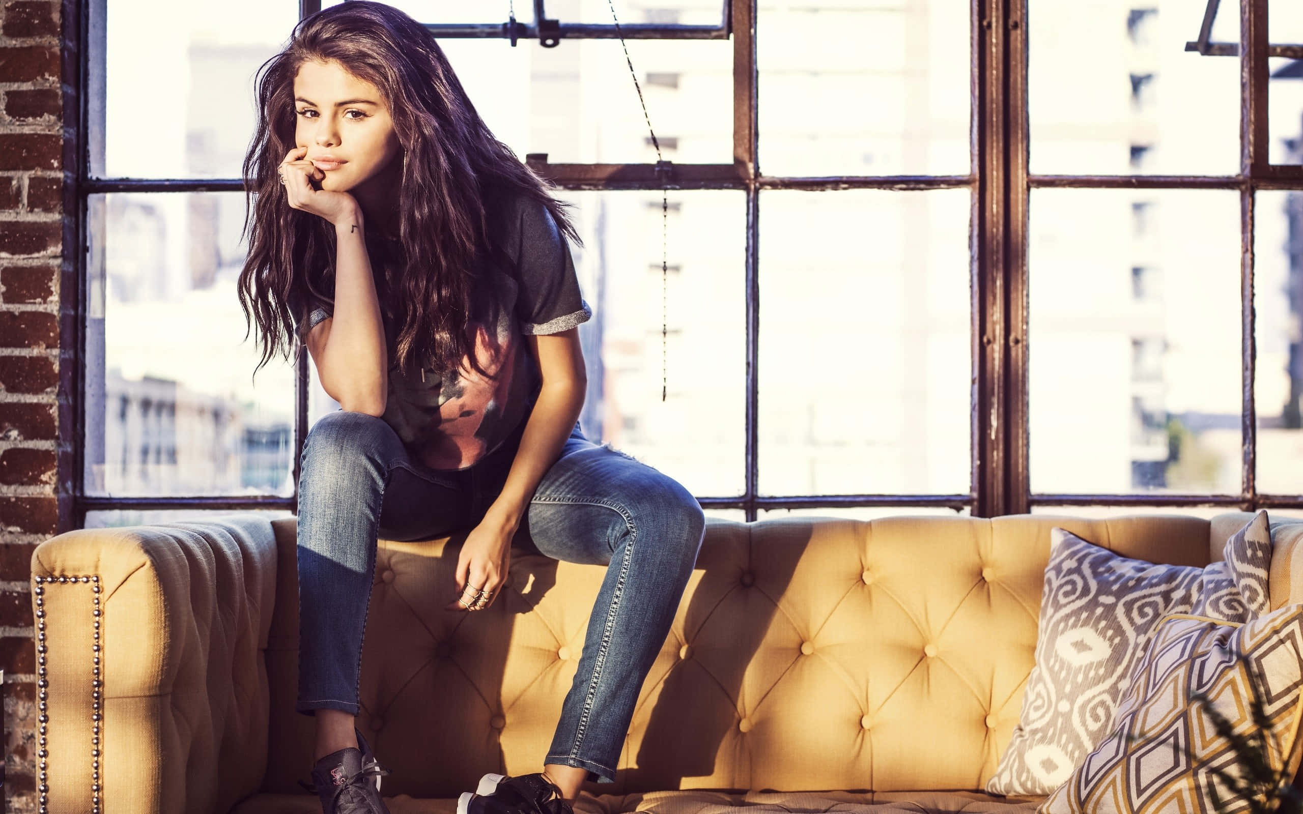Selena Gomez, long dark hair, tufted yellow couch, 2K Desktop Wallpaper