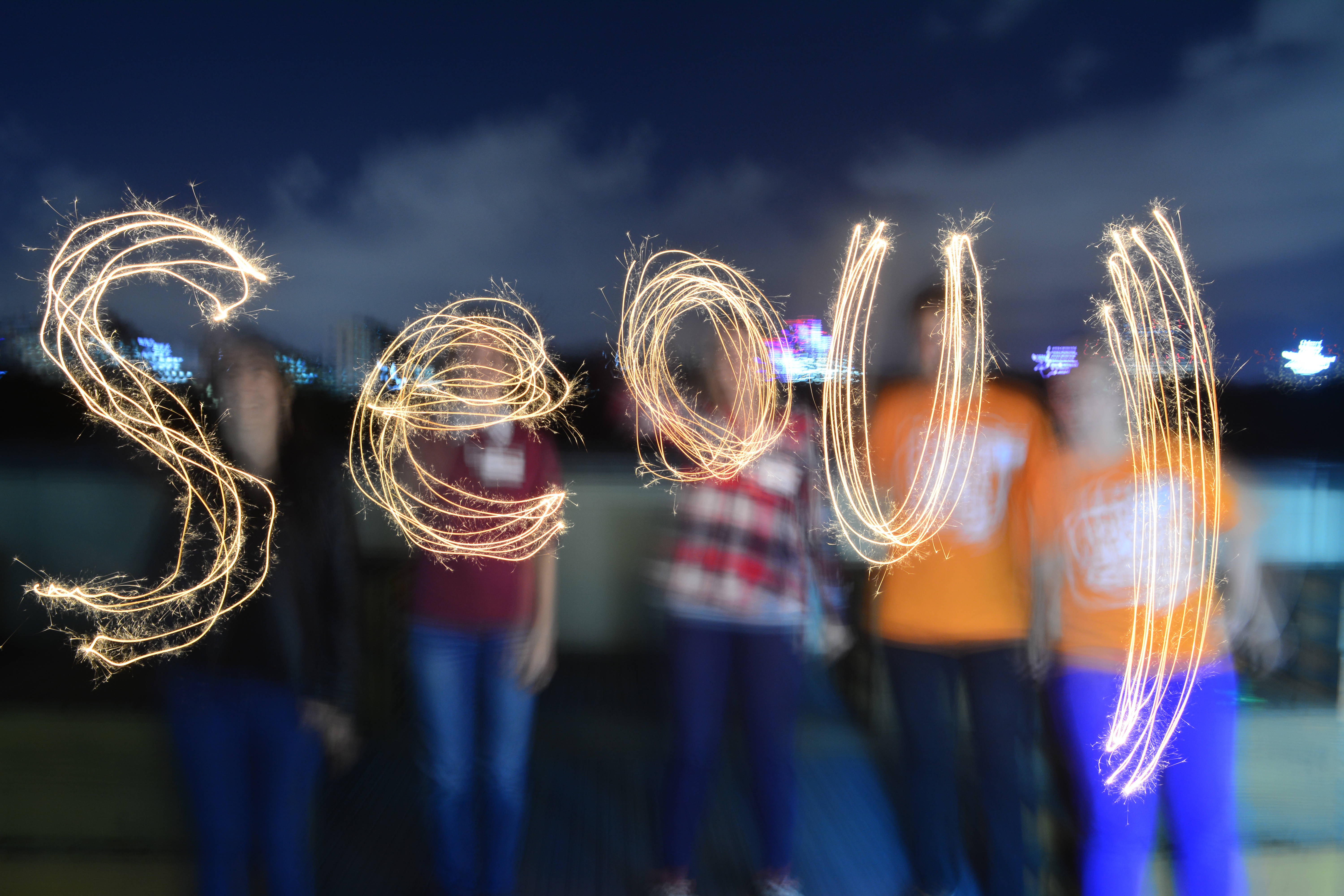 Seoul, glowing sparkler letters, dark city skyline, 5K Desktop Wallpaper