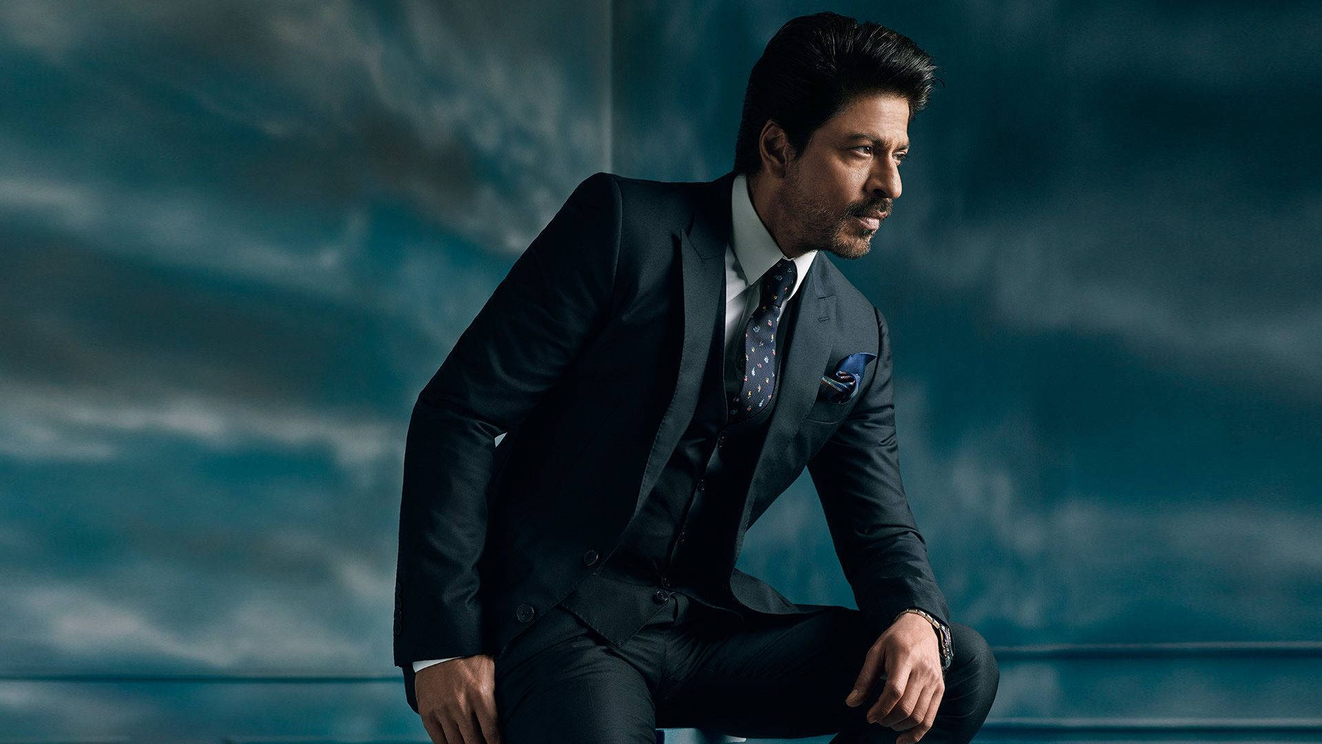 Shahrukh Khan, dark suit, moody teal sky, Full HD Desktop Wallpaper