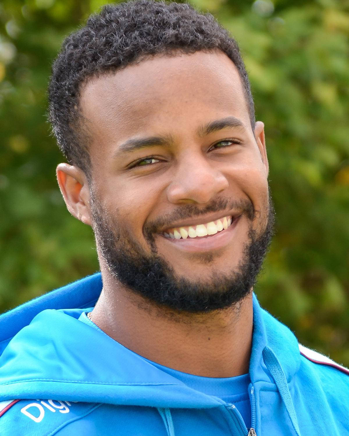 Shai Hope, bright blue hoodie, soft green foliage background, HD Phone Wallpaper