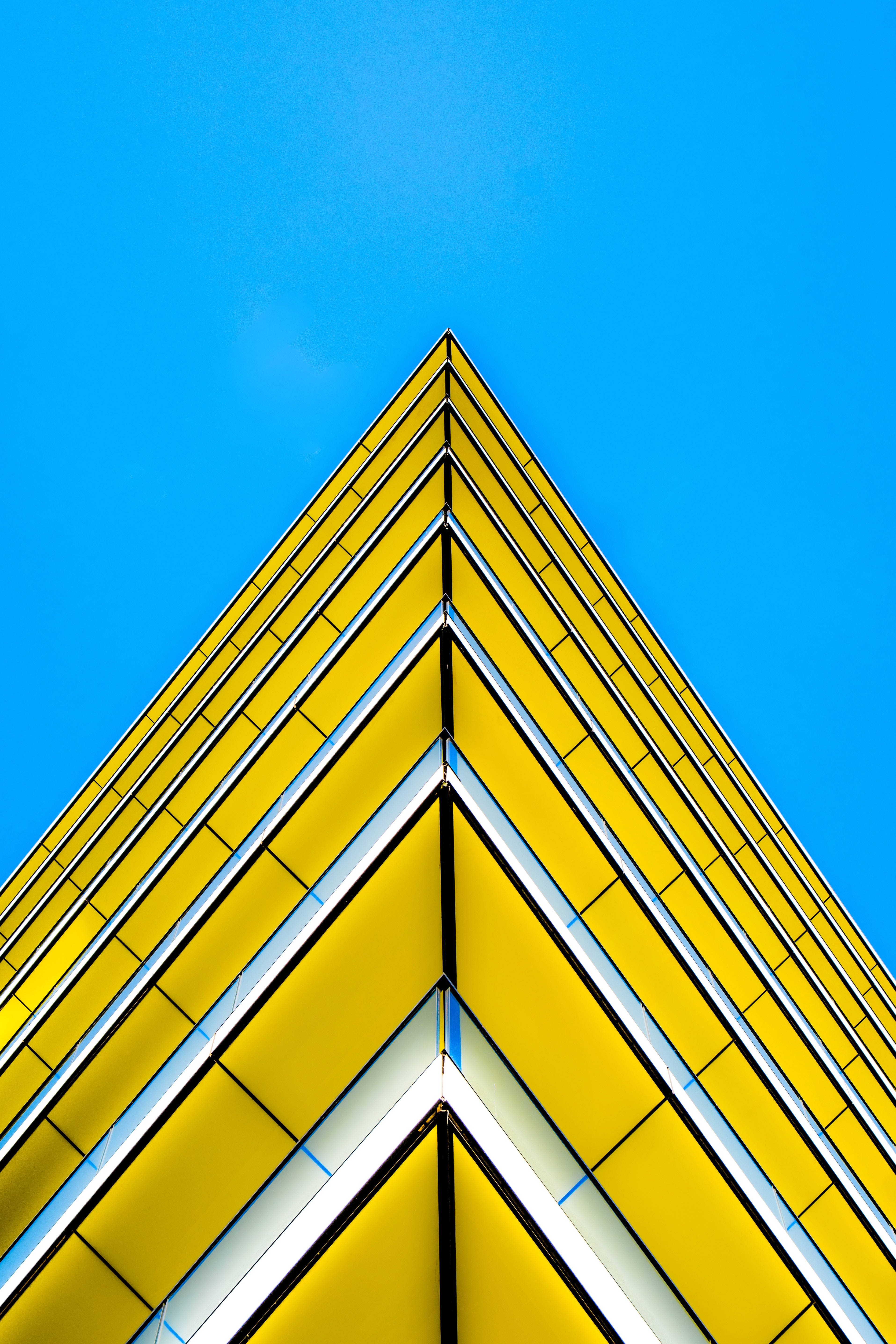 yellow triangle building, sharp edges, clear blue sky, 5K Phone Wallpaper