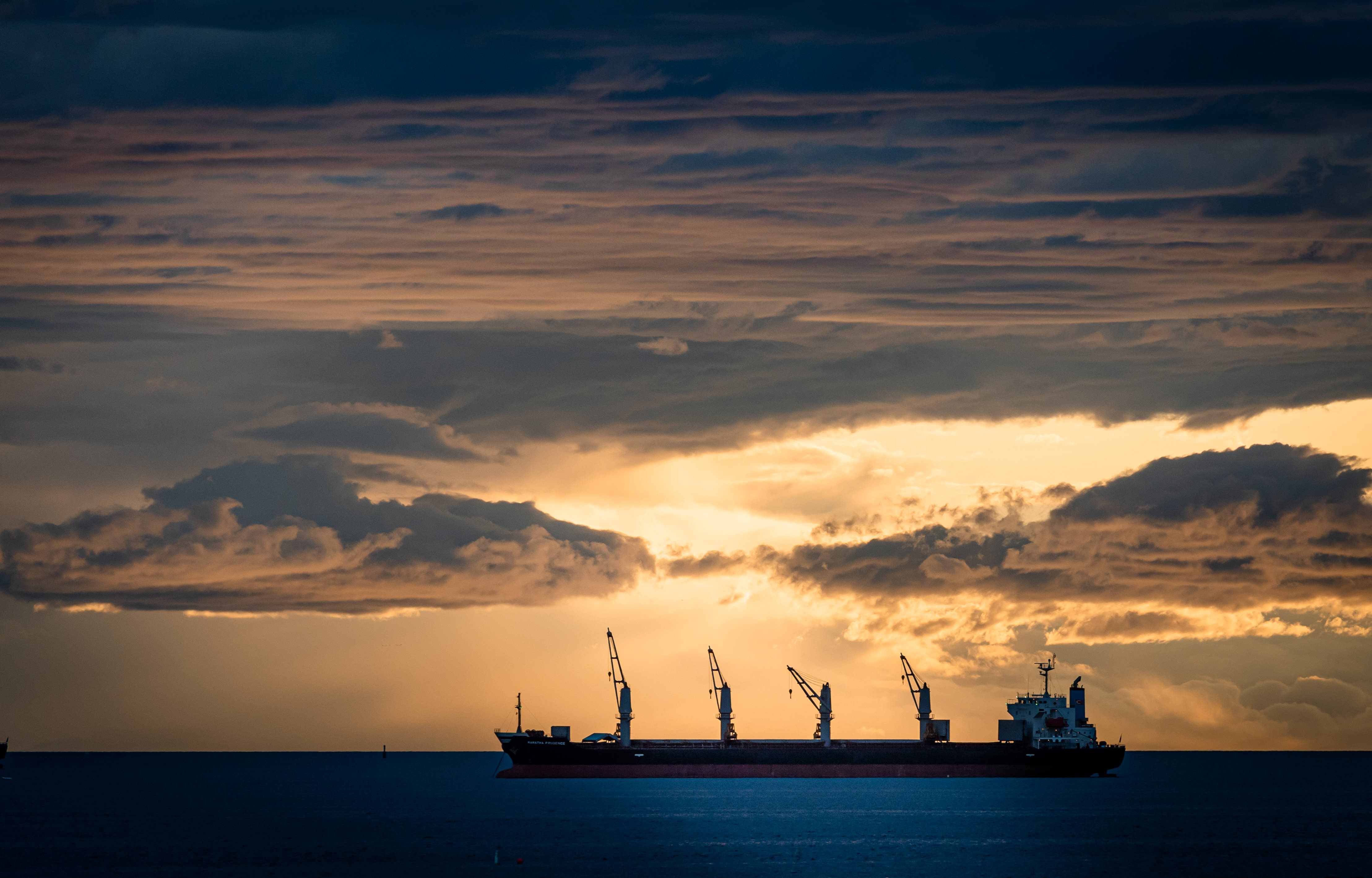 cargo ship, dramatic sunset sky, golden clouds, 4K Desktop Wallpaper