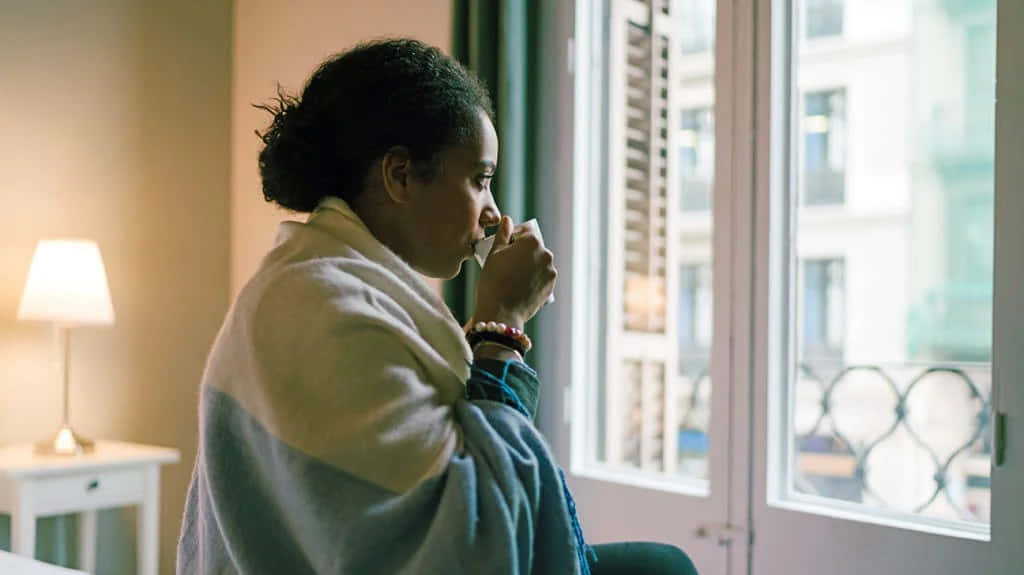 Shivering Woman Drinking Coffee, cozy blanket, sunlit window, SD Desktop Wallpaper