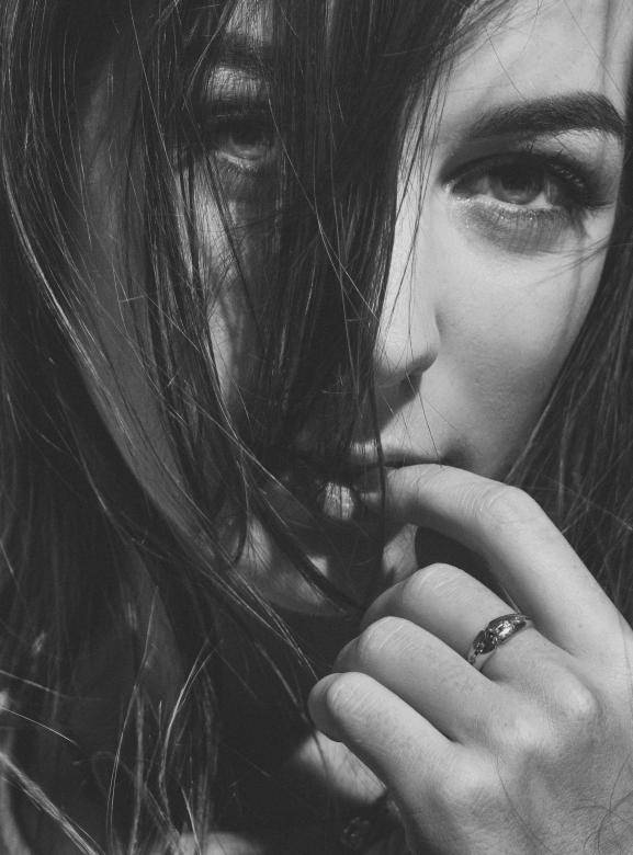 shy woman, dark hair, bites her finger, SD Phone Wallpaper