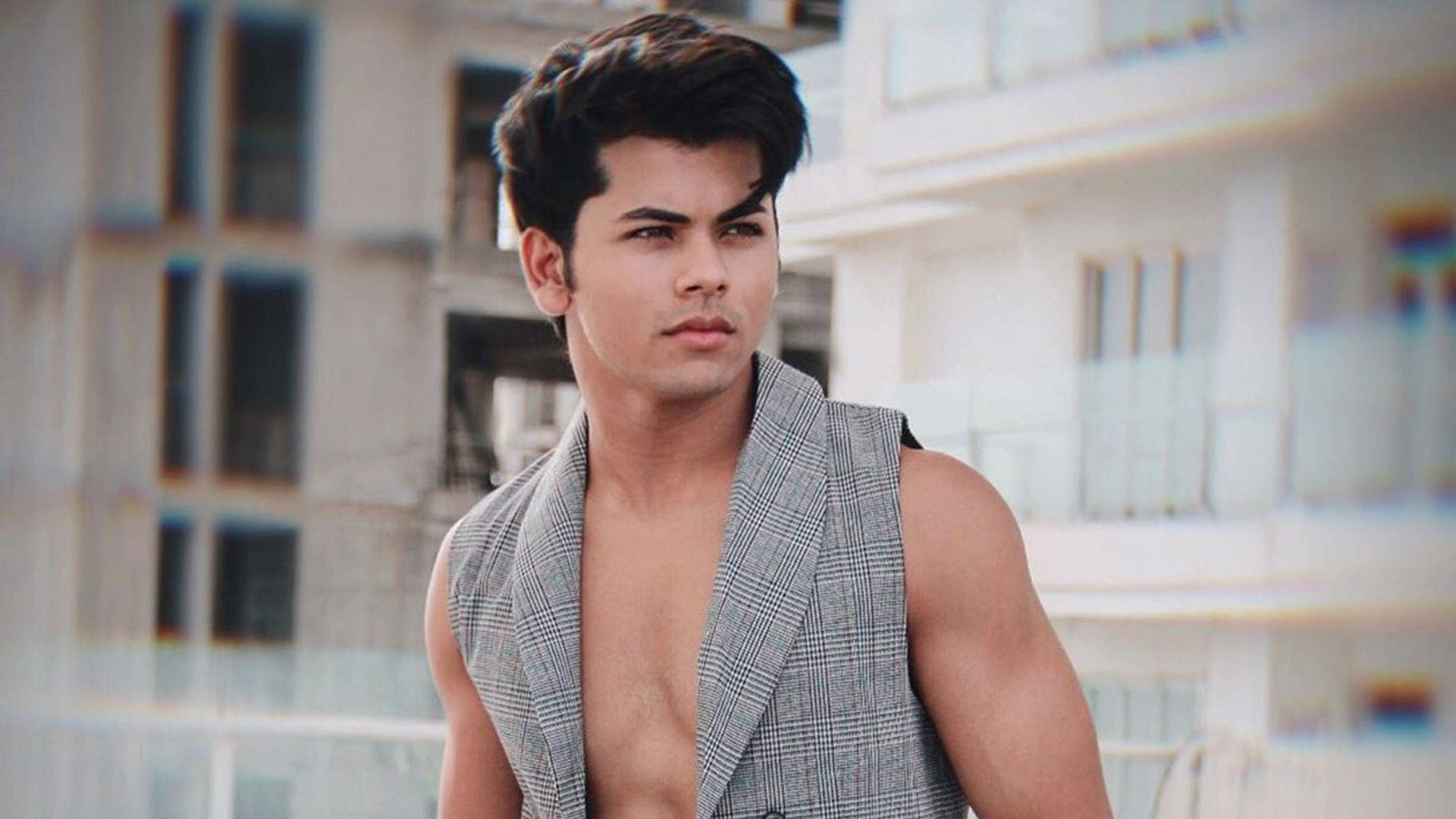 Siddharth Nigam, open checkered vest, blurred urban building backdrop, Full HD Desktop Wallpaper