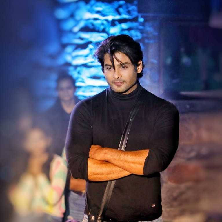 Sidharth Shukla, black turtleneck, blurred blue-lit stone wall, SD Desktop Wallpaper