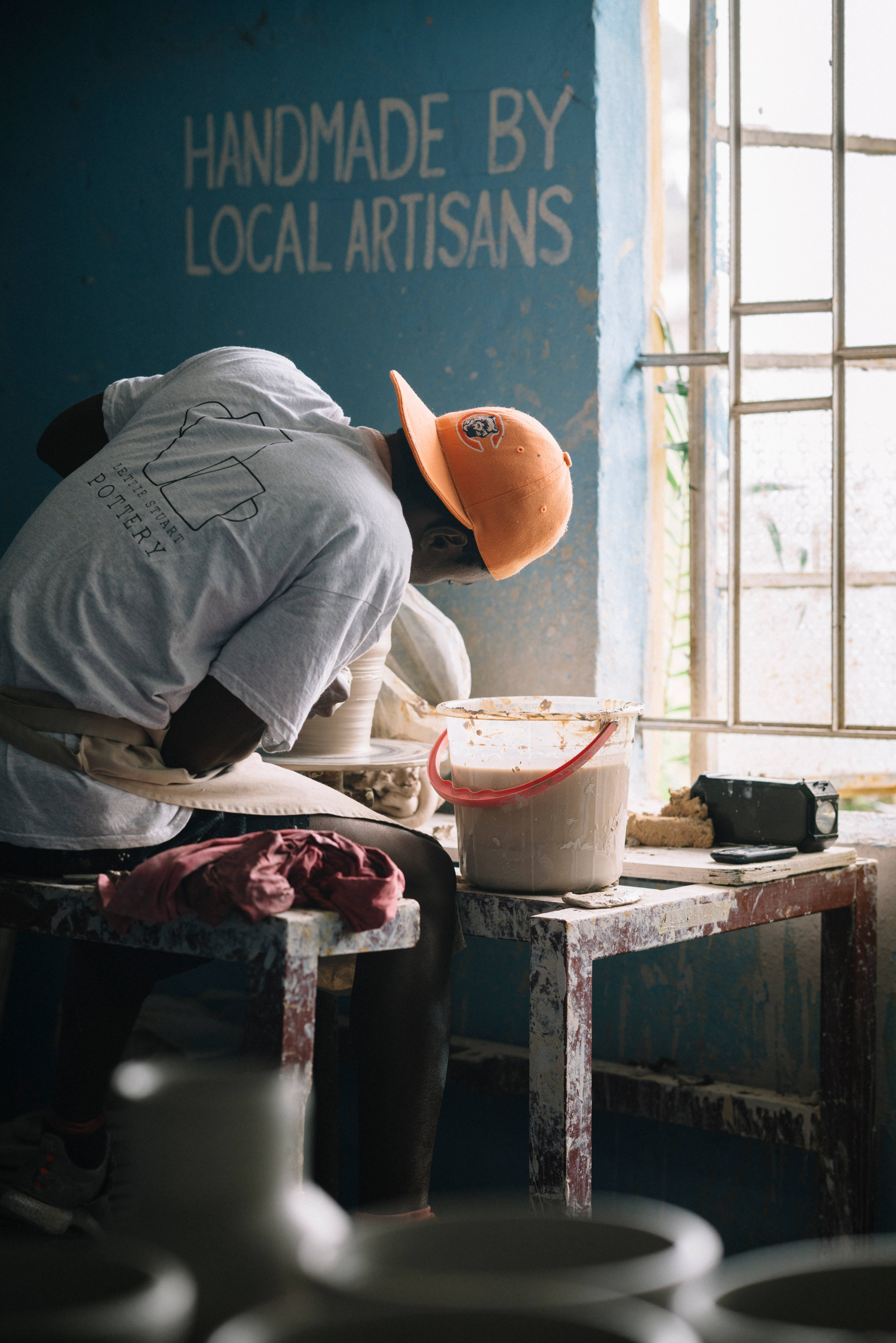 Sierra Leone, orange cap, clay on a wheel, 8K Phone Wallpaper