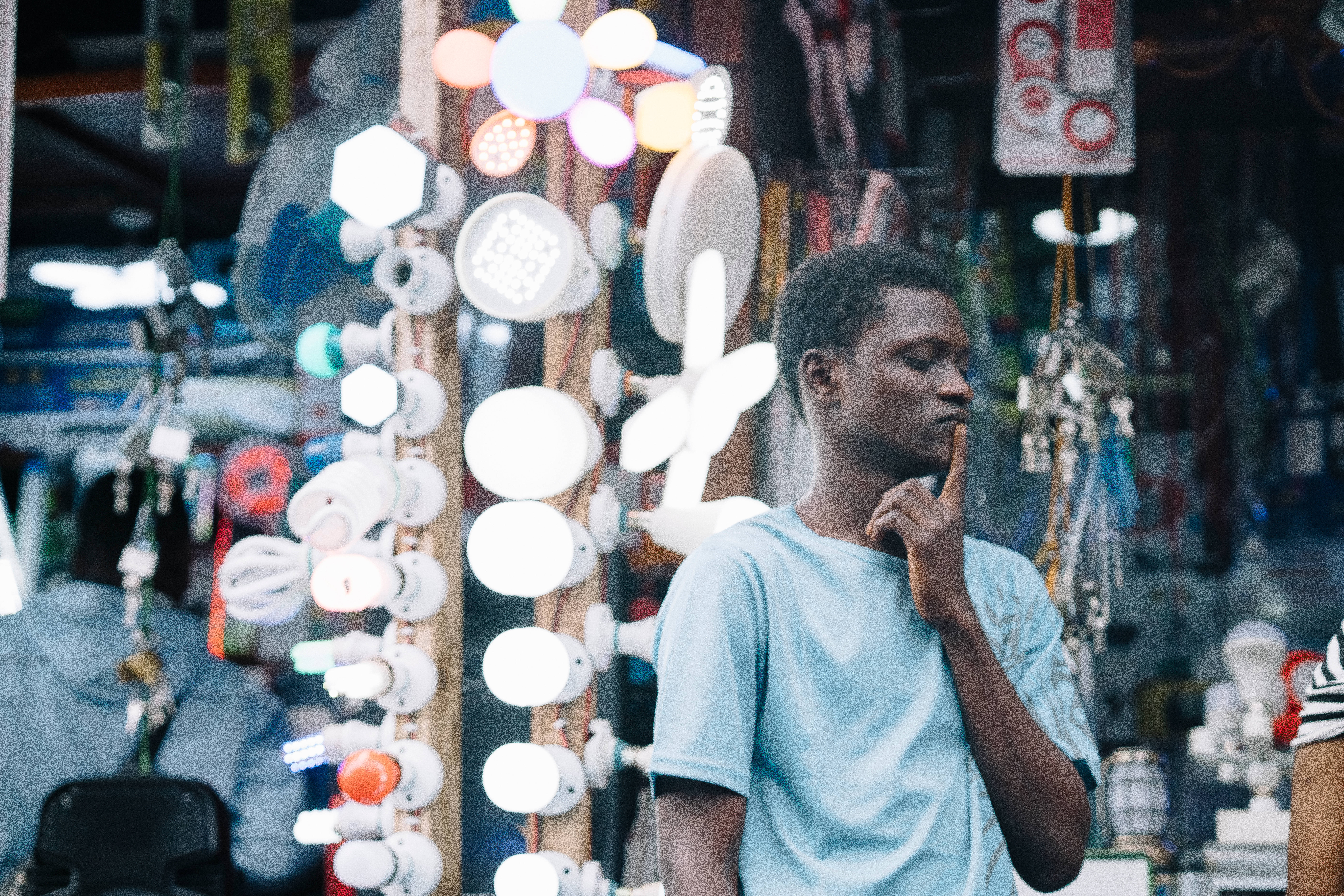 Sierra Leone, light blue shirt, bustling electronics shop, 8K Desktop Wallpaper