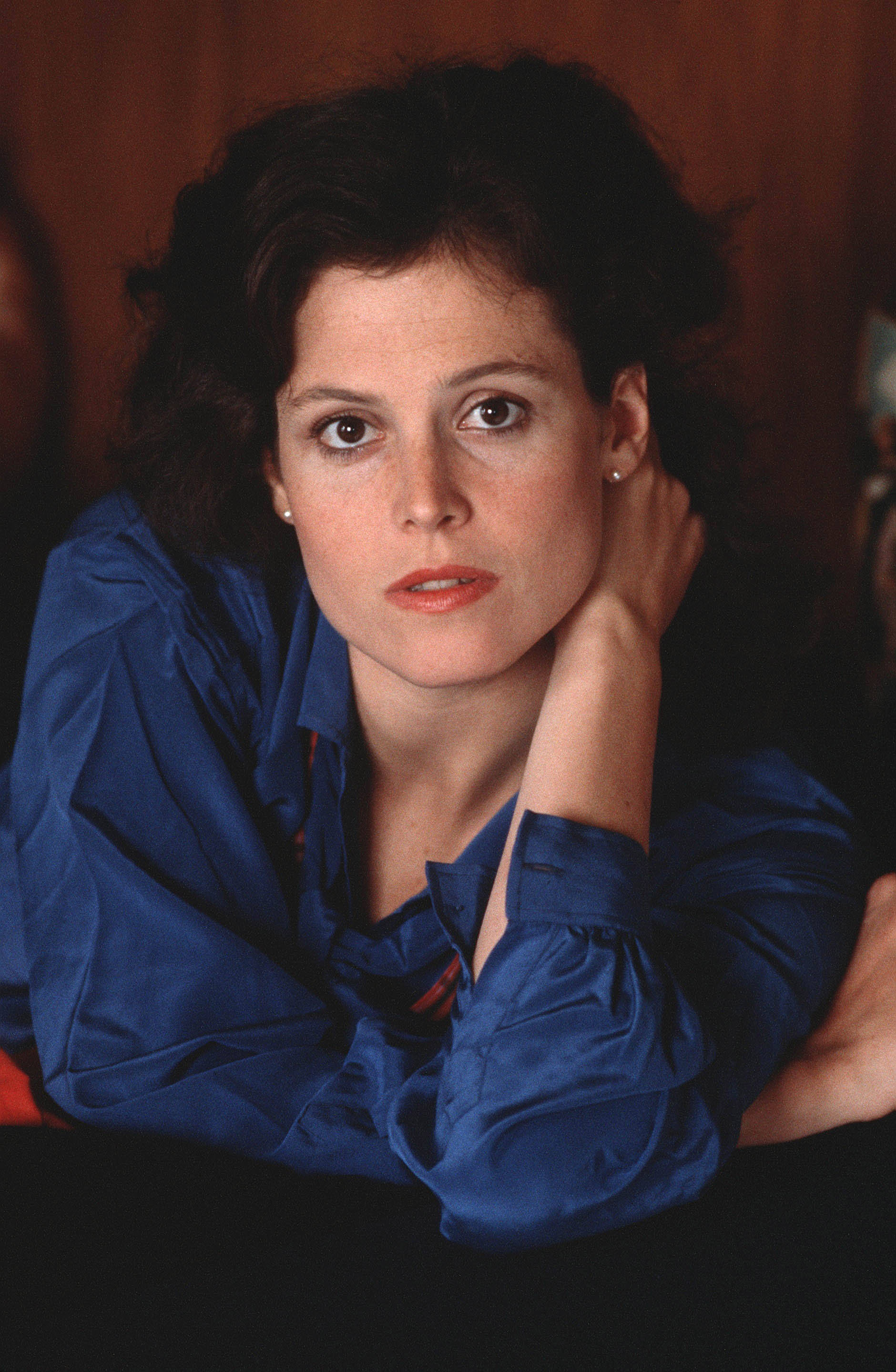 Sigourney Weaver, dark curly hair, vibrant blue blouse, 2K Phone Wallpaper