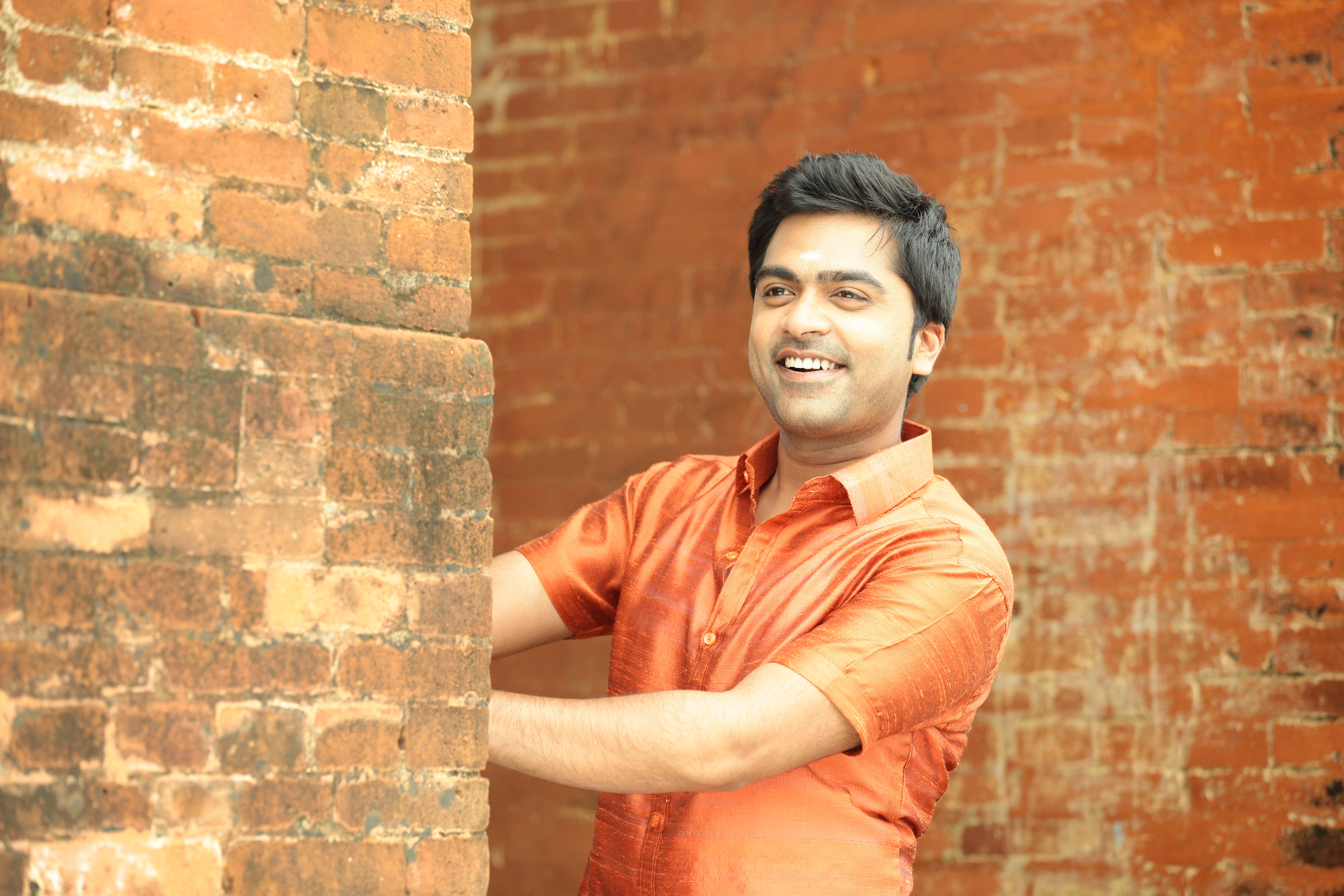 Simbu, orange shirt, weathered brick wall, 5K Desktop Wallpaper