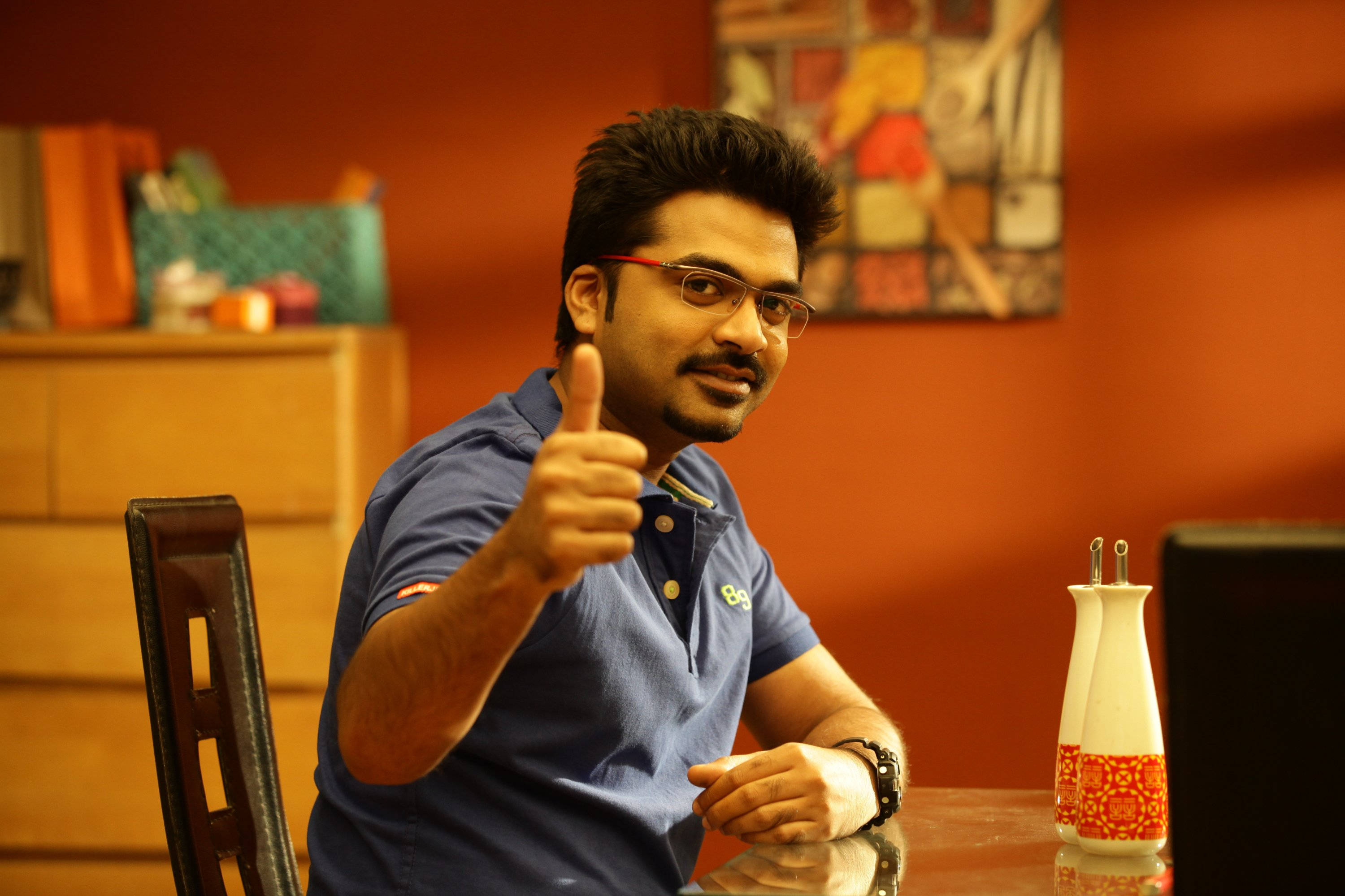Simbu, blue polo shirt, wooden table, 2K Desktop Wallpaper