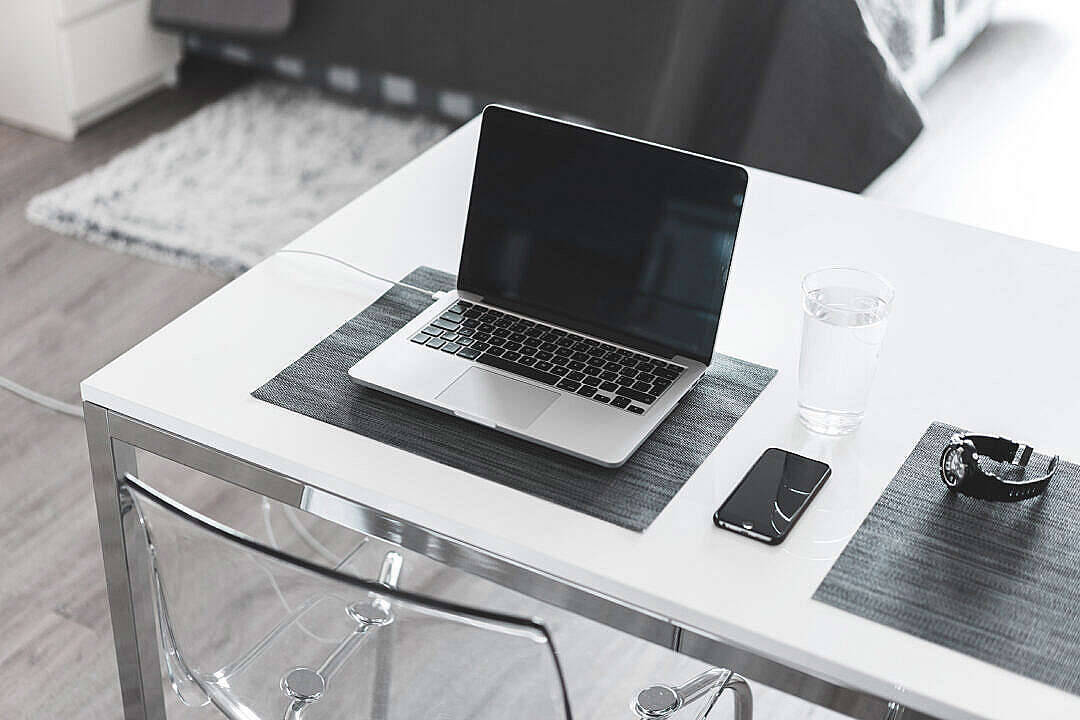 sleek silver laptop, white desk, glass of water, SD Desktop Wallpaper