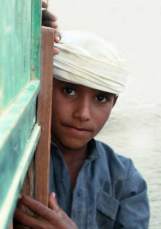 shy boy, white headwrap, weathered green wooden door frame, SD Phone Wallpaper