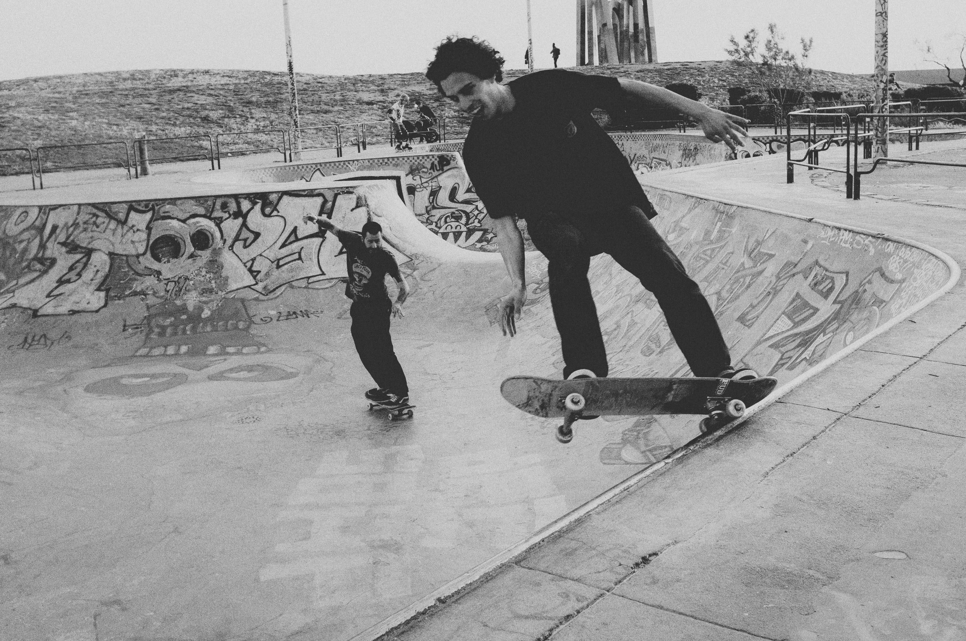 black and white, skateboarders, graffiti-covered concrete skatepark, 4K Desktop Wallpaper