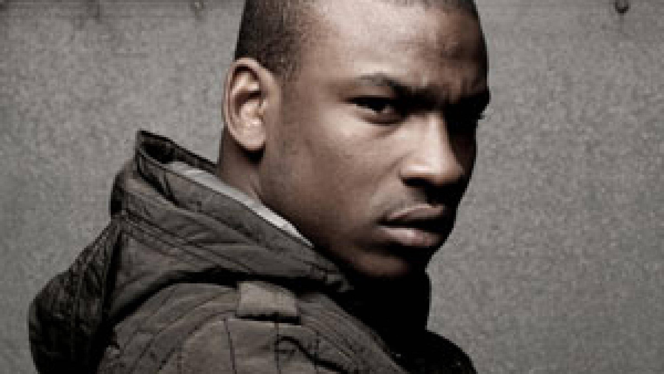 Skepta, live on stage, moody monochrome portrait, 2K Desktop Wallpaper