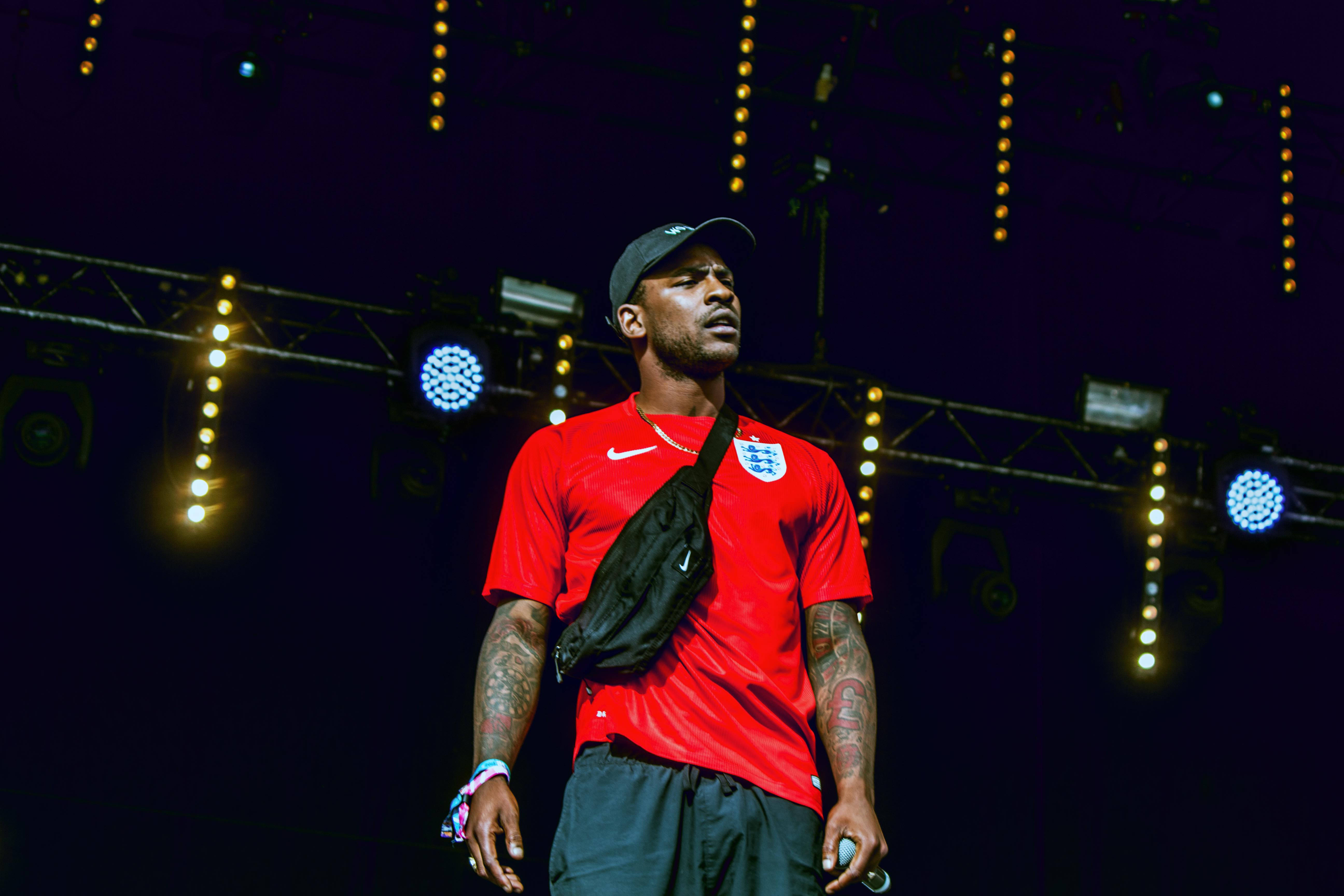 Skepta, red England football jersey, dimly lit stage, 5K Desktop Wallpaper