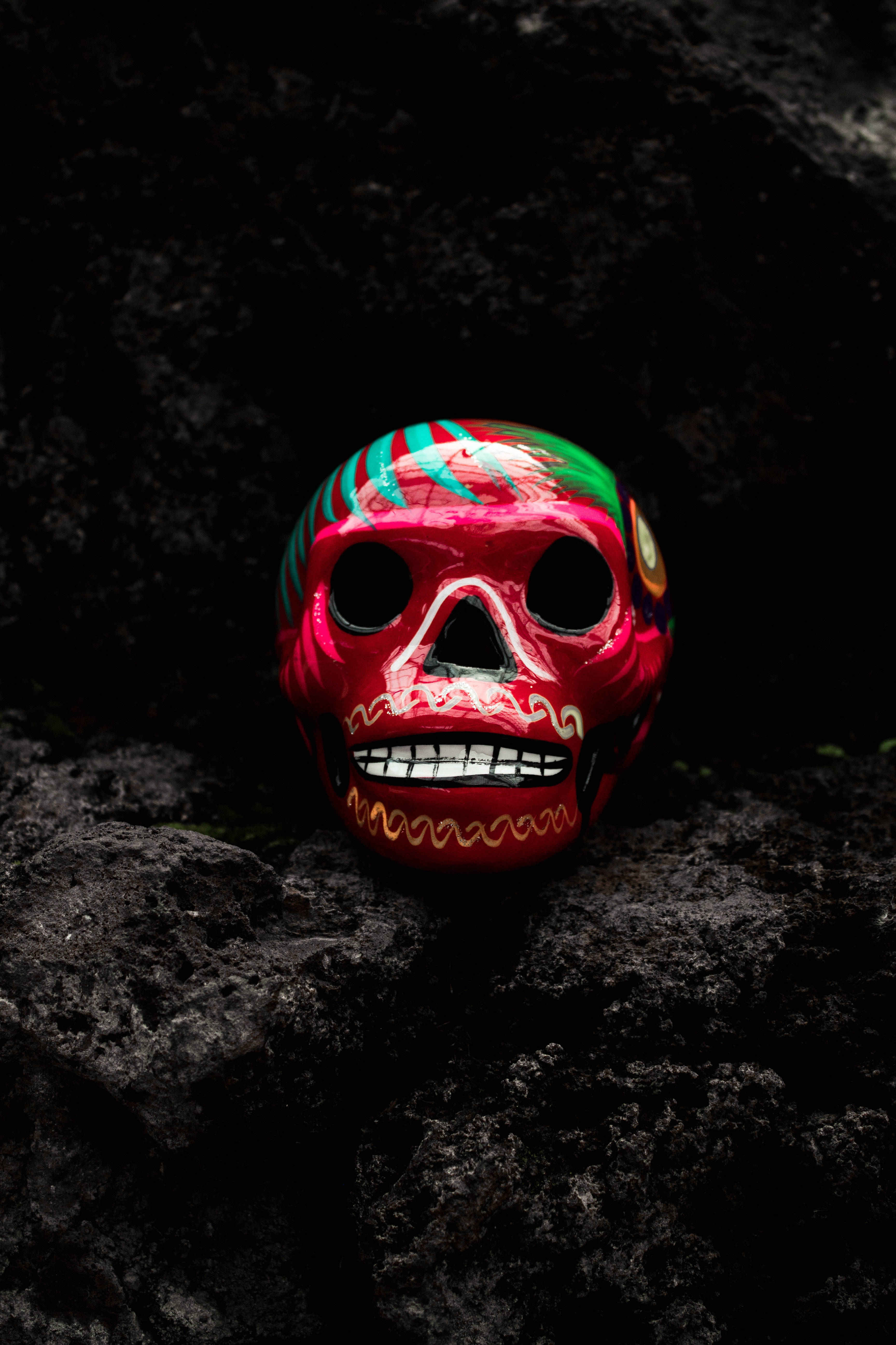 red sugar skull, green and turquoise accents, dark textured rocks, 5K Phone Wallpaper