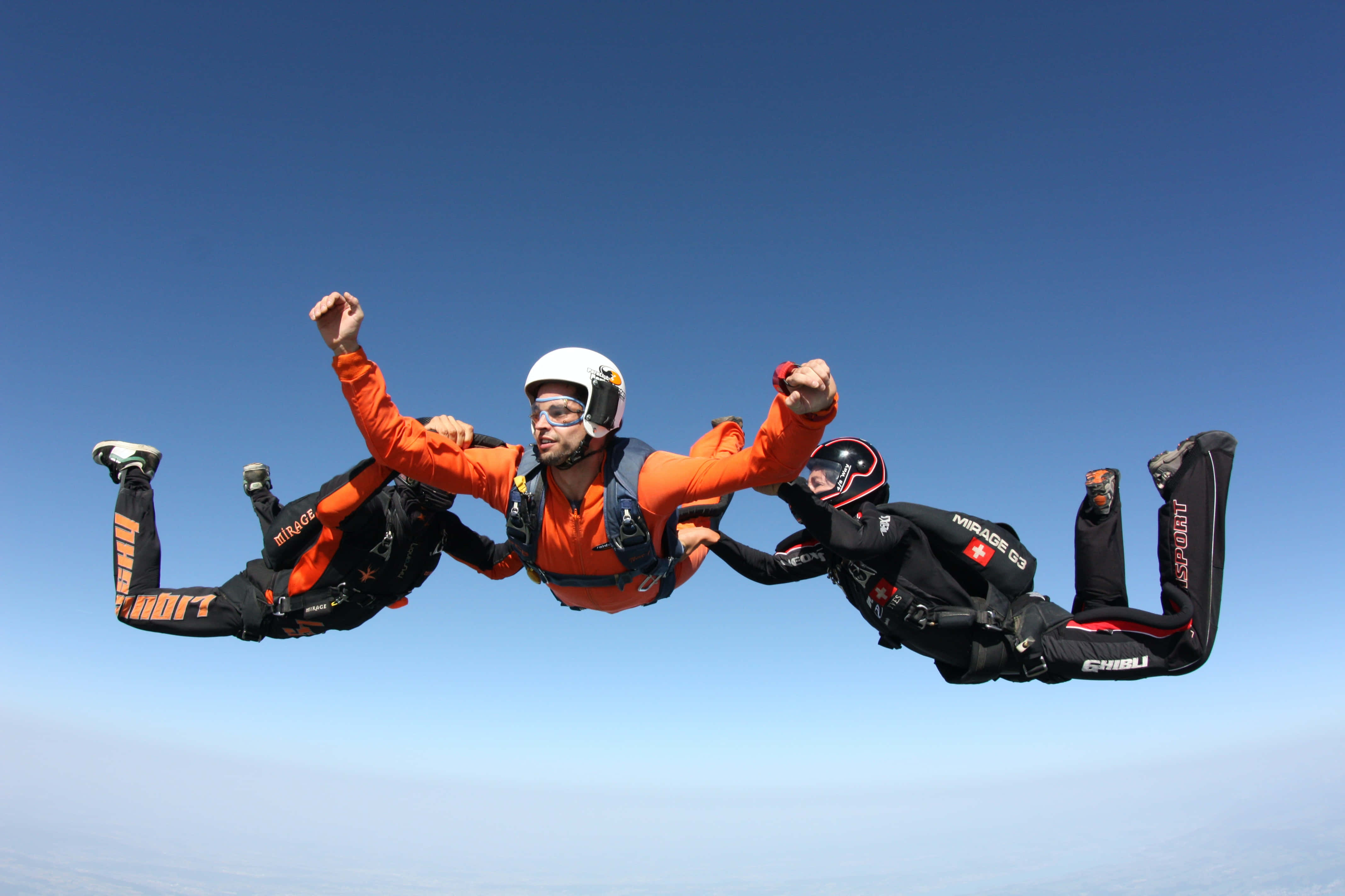 orange and black gear, clear blue sky, arms raised in triumph, 4K Desktop Wallpaper