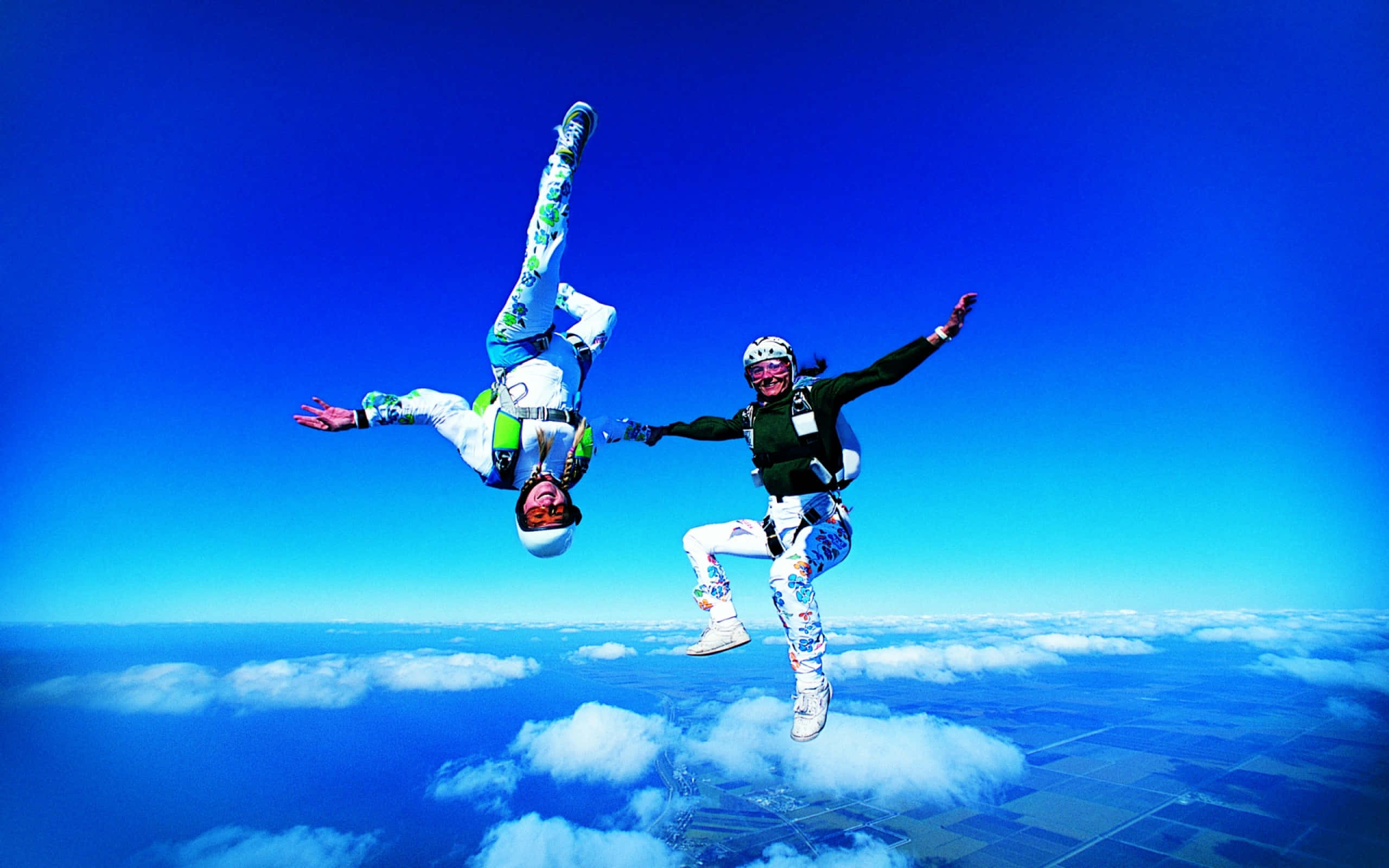female skydiving, colorful suits, vivid blue sky, 2K Desktop Wallpaper