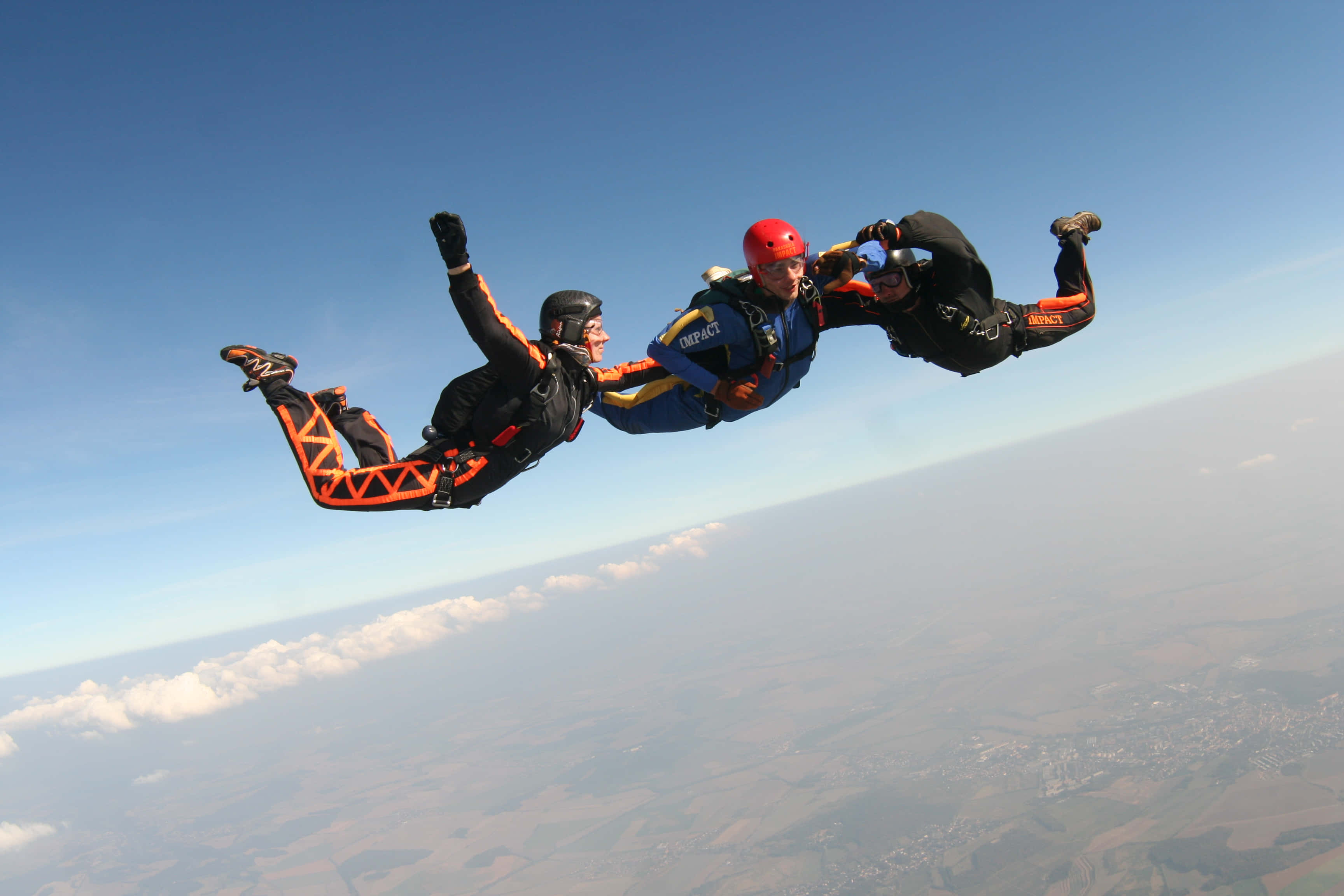 tandem jumping skydiving, orange and black gear, clear blue sky, 2K Desktop Wallpaper