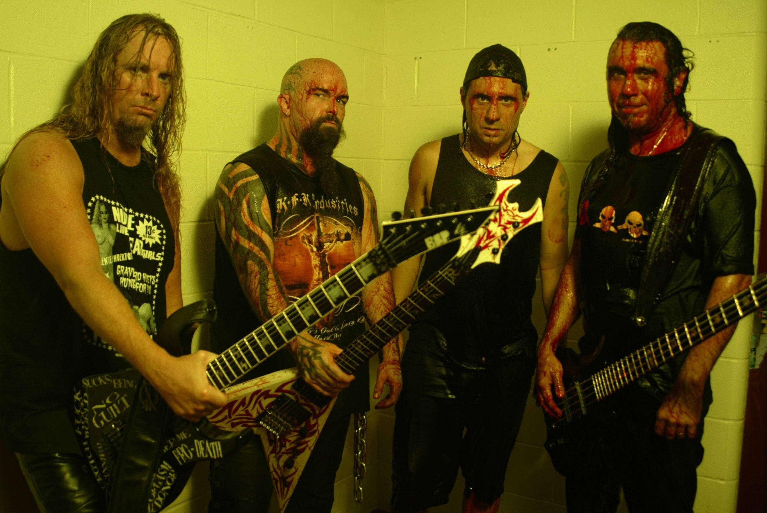 Slayer, bloodied faces, yellow-tinted cinder block wall, 2K Desktop Wallpaper