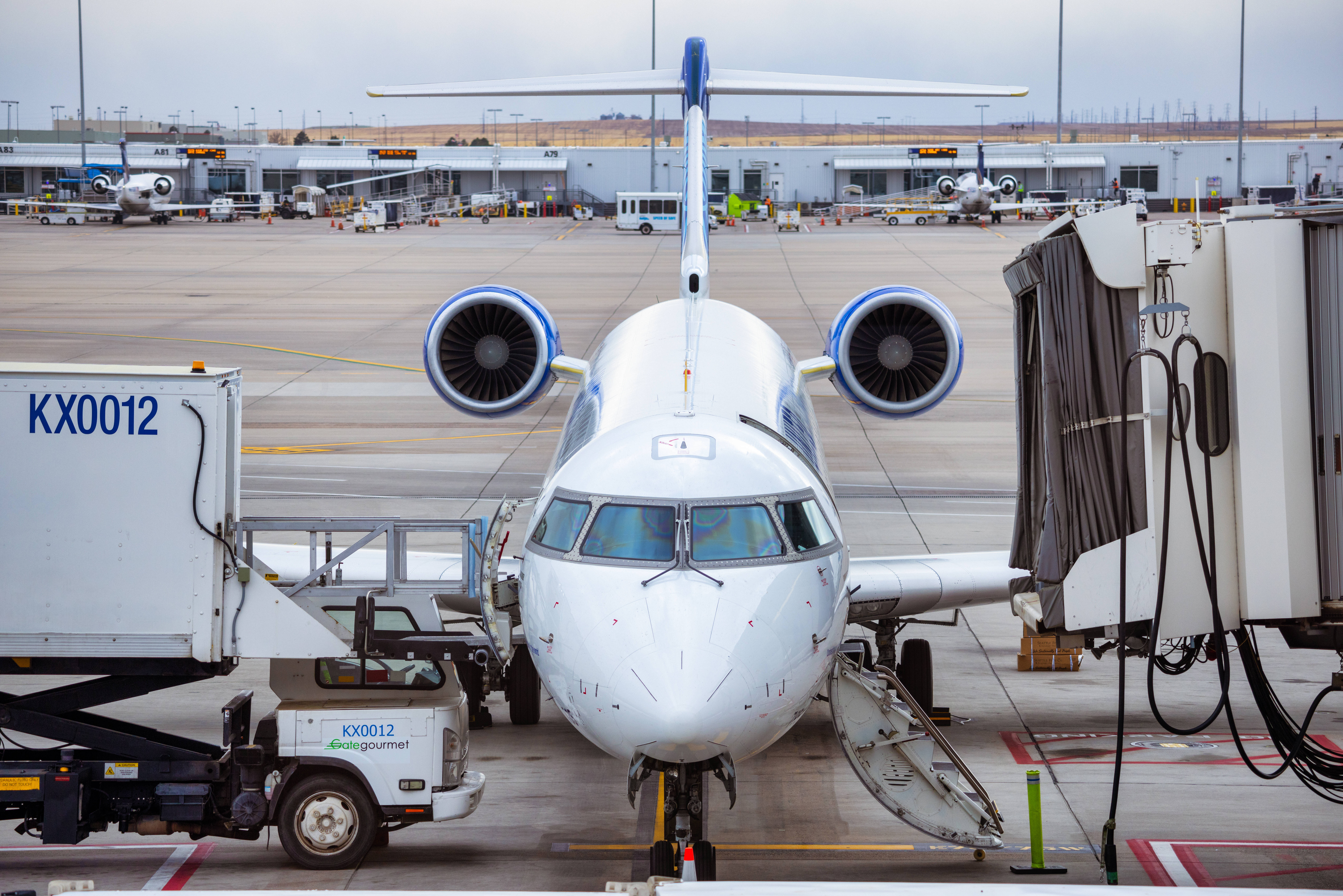 white twin-engine jet airplane, airport gate, jet bridge, 8K Desktop Wallpaper