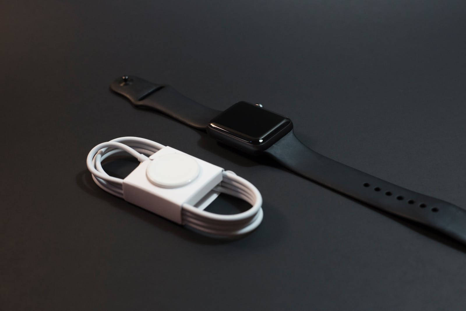 black smartwatch, white charging cable, dark matte surface, HD Desktop Wallpaper