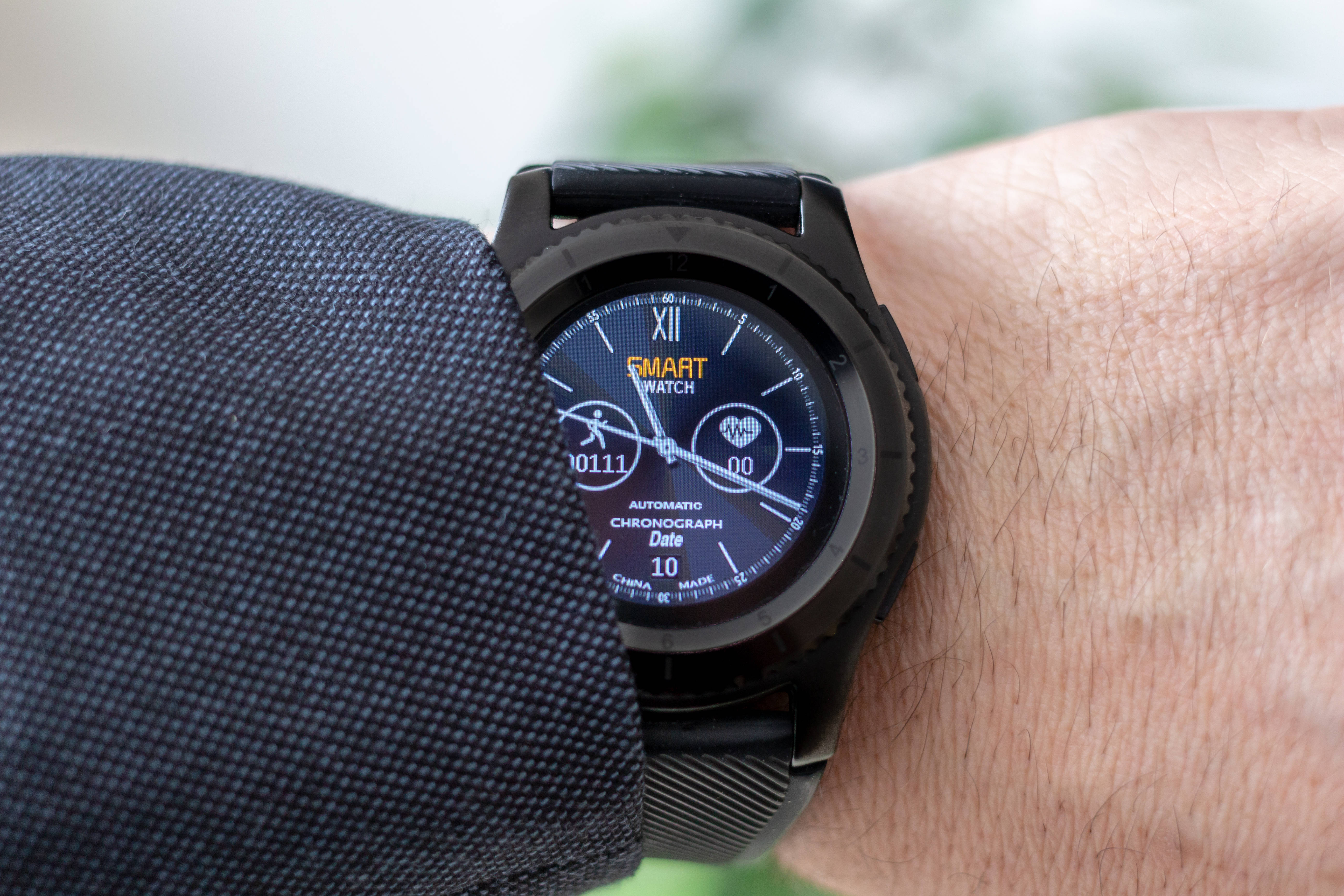 black smartwatch, dark textured sleeve, blurred green background, 5K Desktop Wallpaper