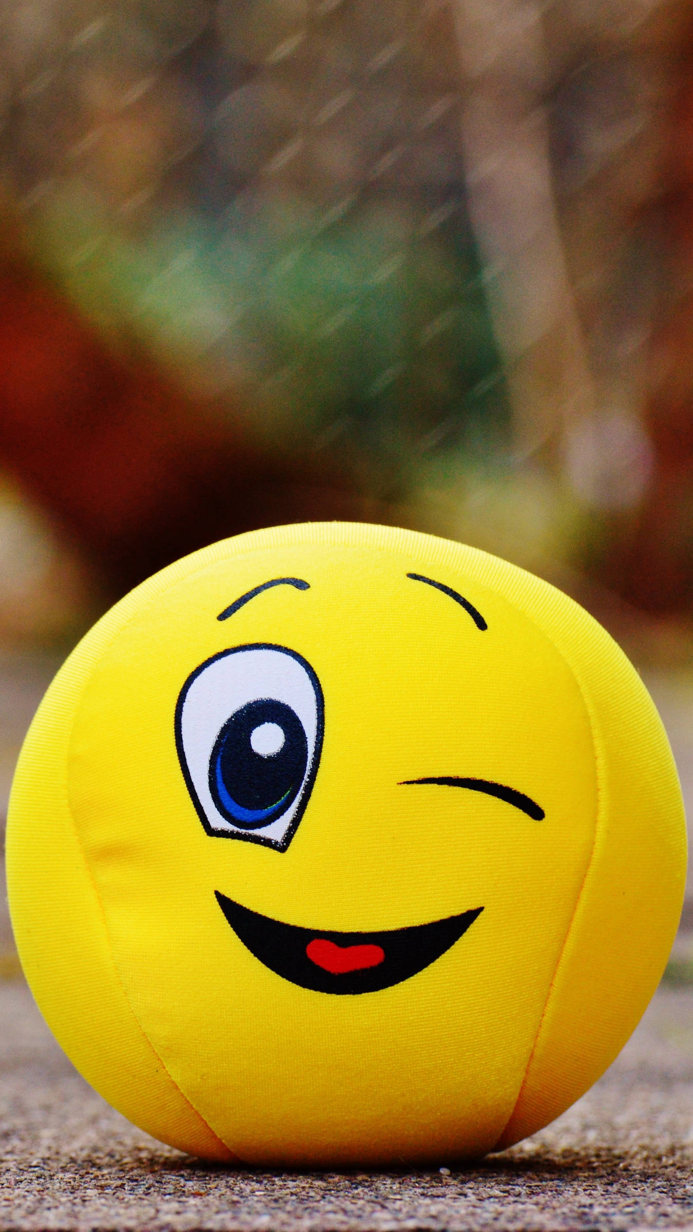 winking smiley face ball cushion, bright yellow plush, one eye open and one closed, Full HD Phone Wallpaper