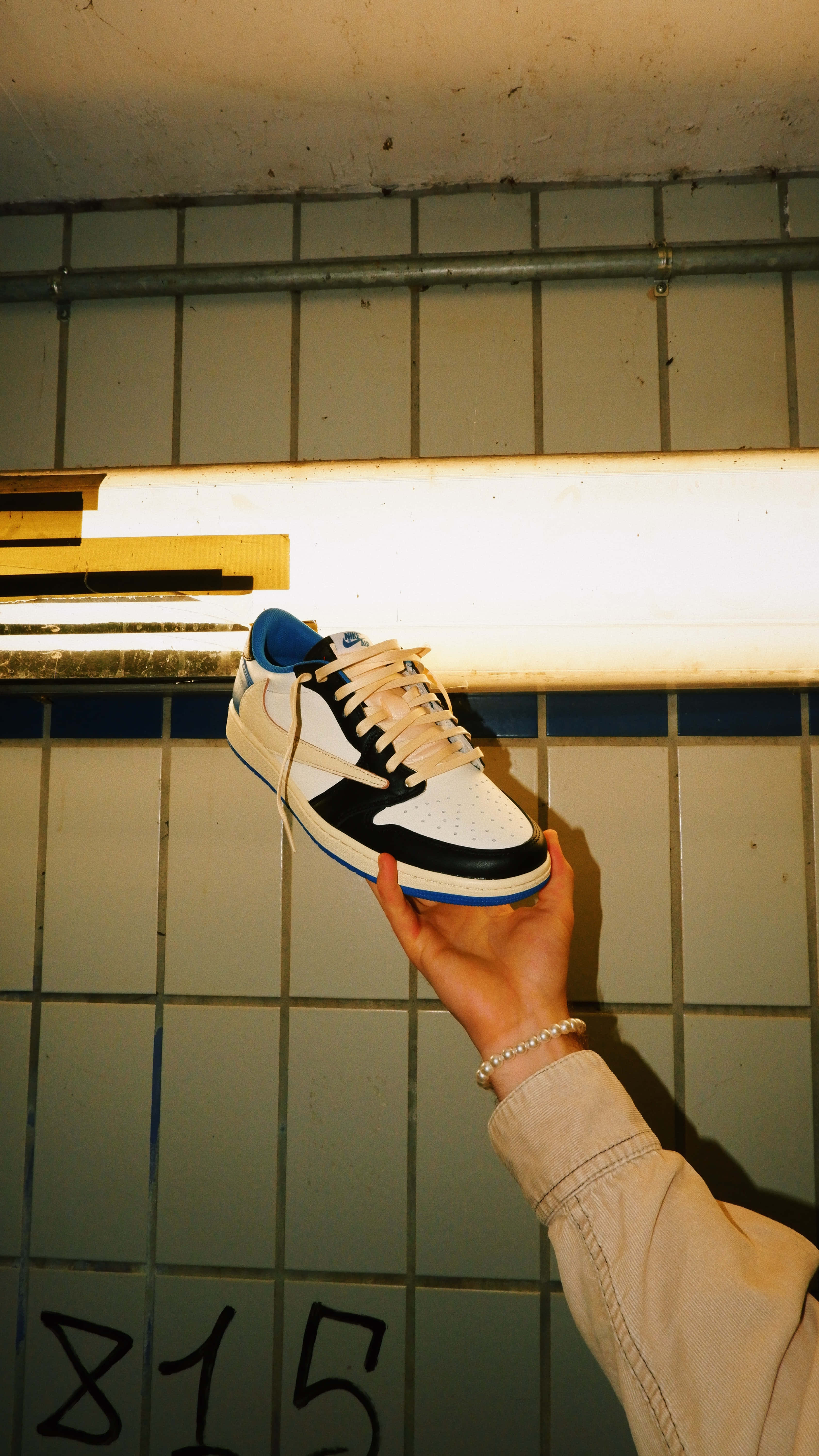 white black and blue sneaker, tiled wall, warm fluorescent light, 5K Phone Wallpaper