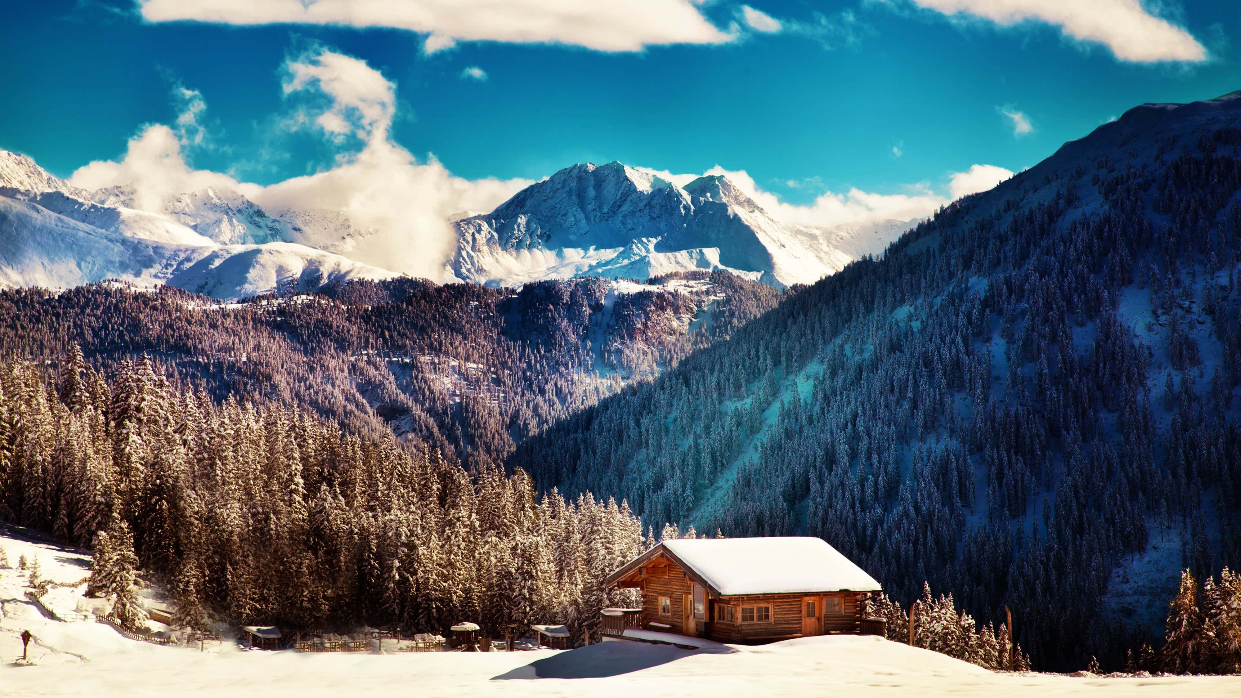 snow-covered pine forests, majestic snow-capped mountains, cozy wooden cabin, 4K Desktop Wallpaper