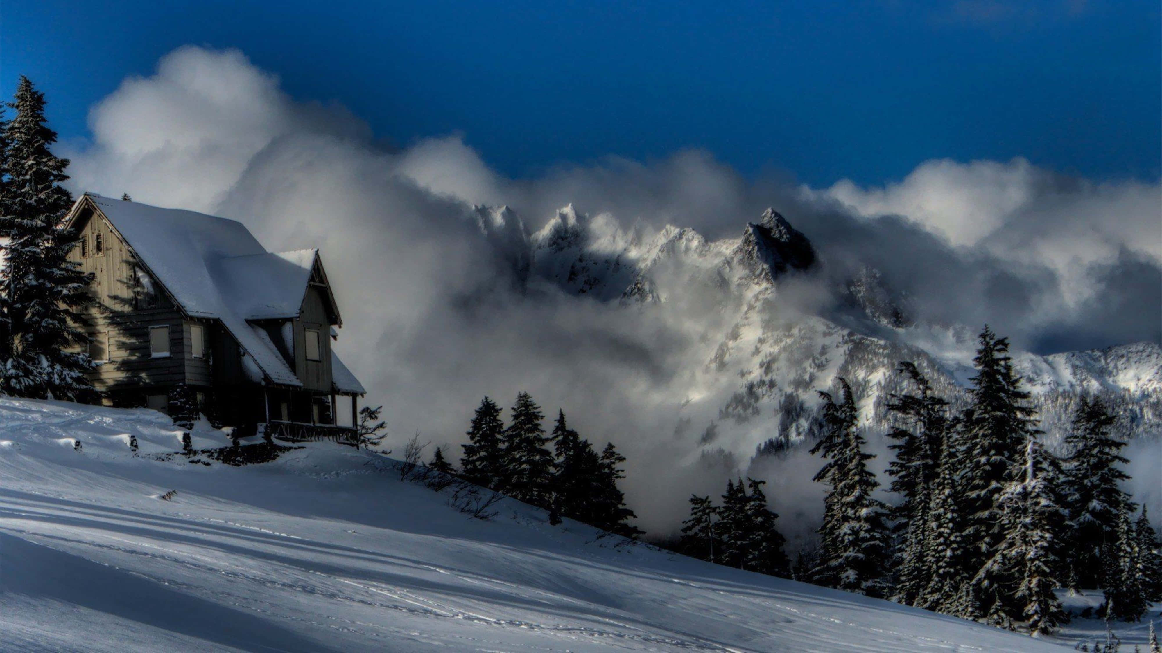 snow-covered cabin, mountain slope, clouds swirl, 4K Desktop Wallpaper