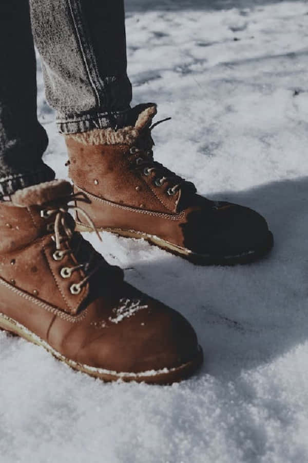 snowshoes, rugged brown winter boots, snow dusted on the soles, SD Phone Wallpaper