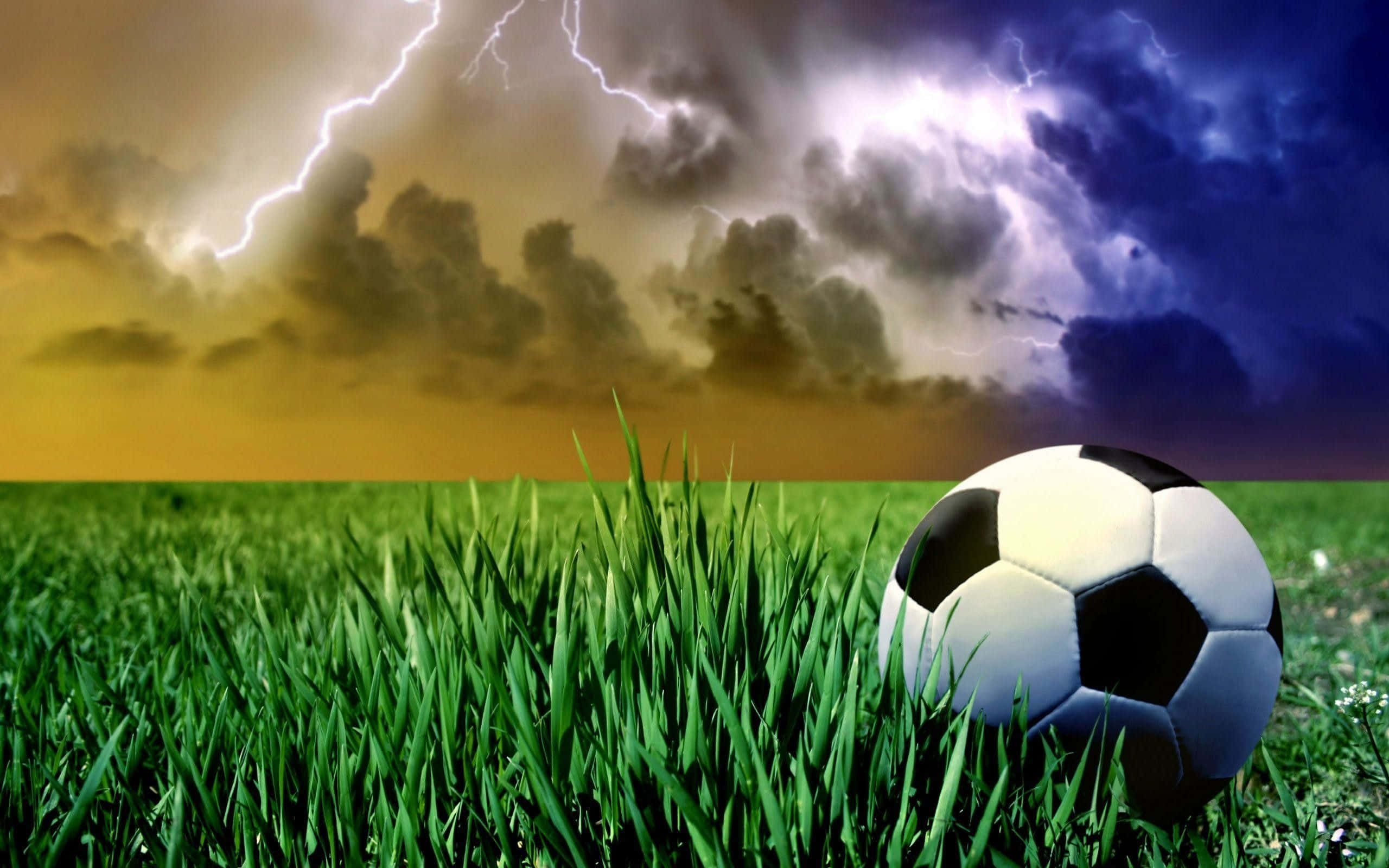 soccer ball, vibrant green grass, dramatic sky, 2K Desktop Wallpaper