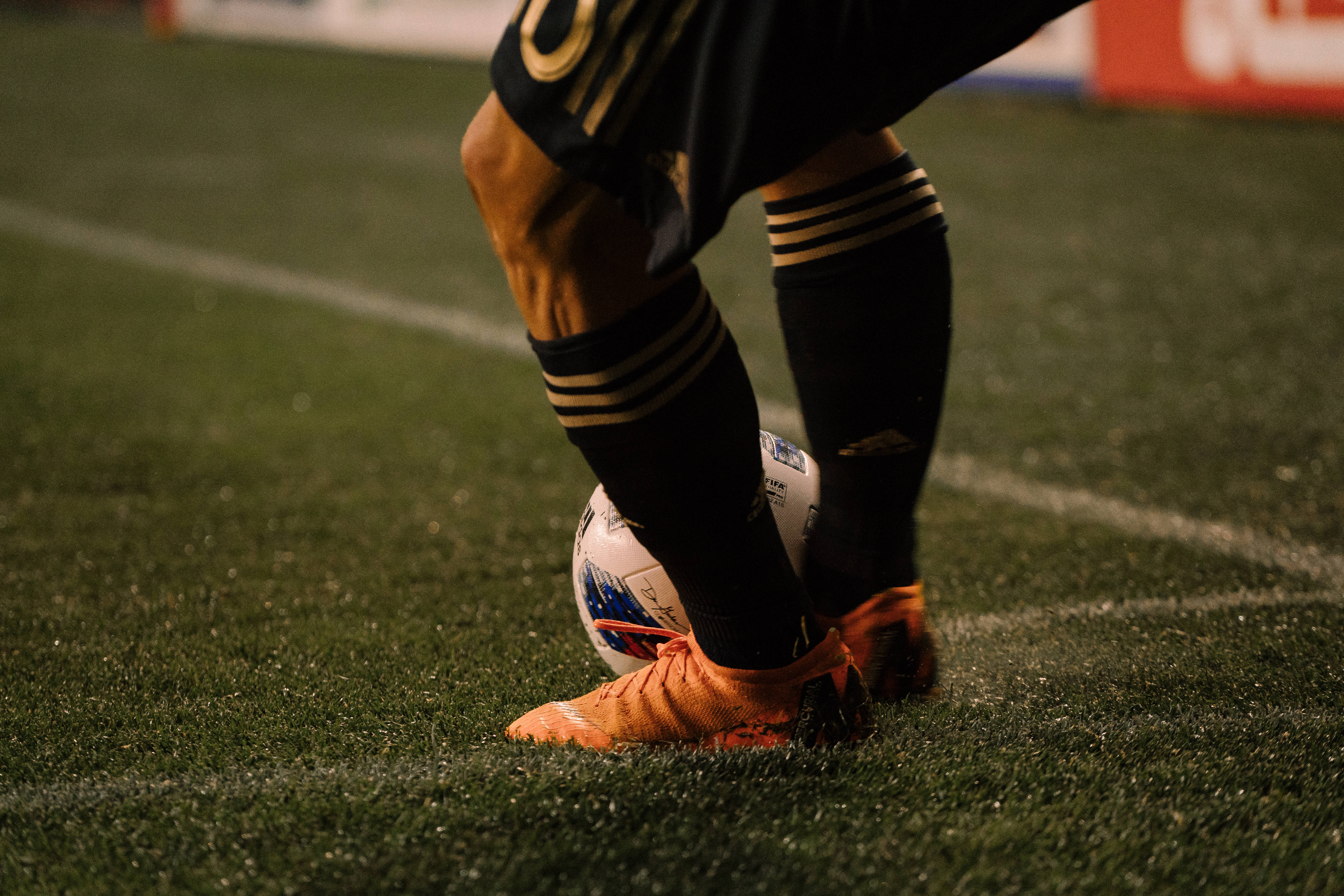 orange cleats, white ball, green turf field, 5K Desktop Wallpaper